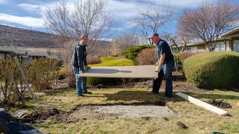 Perma-Pad being installed in a residential backyard. The pad provides a stable and level base for outdoor furniture or equipment.