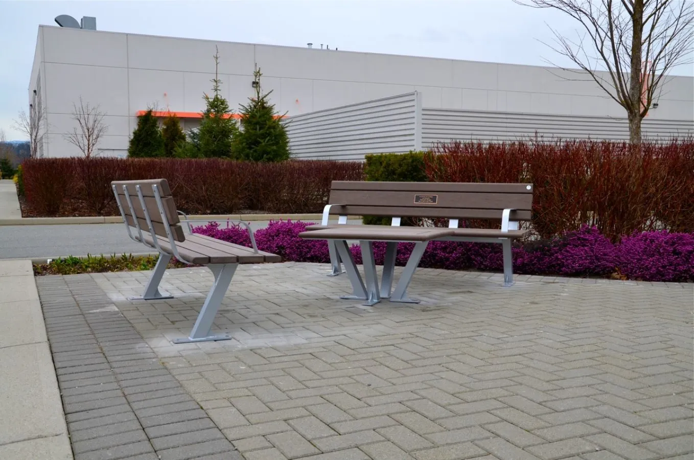 Bayview benches and a coffee table create an inviting outdoor seating area. The furniture features recycled plastic lumber and powder-coated metal frames.
