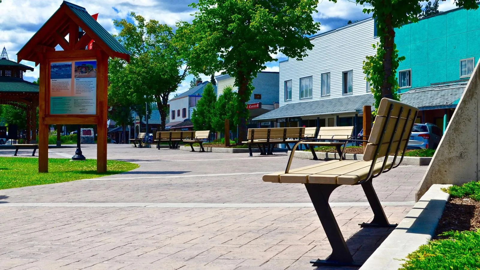 Durable benches provide seating in a public square. The site furniture complements the surrounding architecture and landscaping.