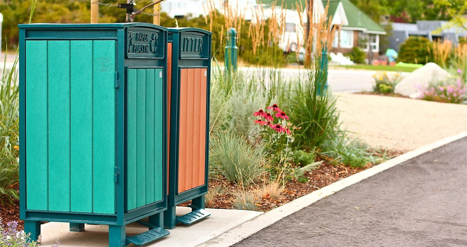 Dual Beselt Square Top Waste Receptacles with foot pedals provide convenient disposal options in an outdoor setting. The units feature recycled plastic lumber in contrasting colors and durable powder-coated metal frames.