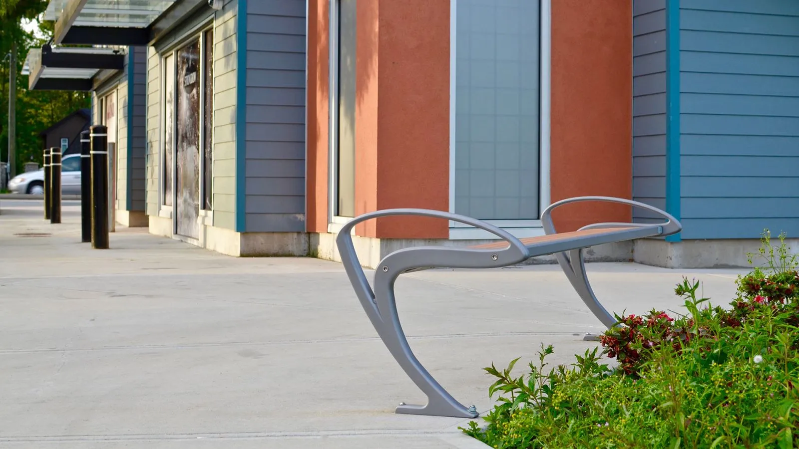 This TENAJ bench offers comfortable seating in a commercial area. The bench features a sleek design and durable construction.