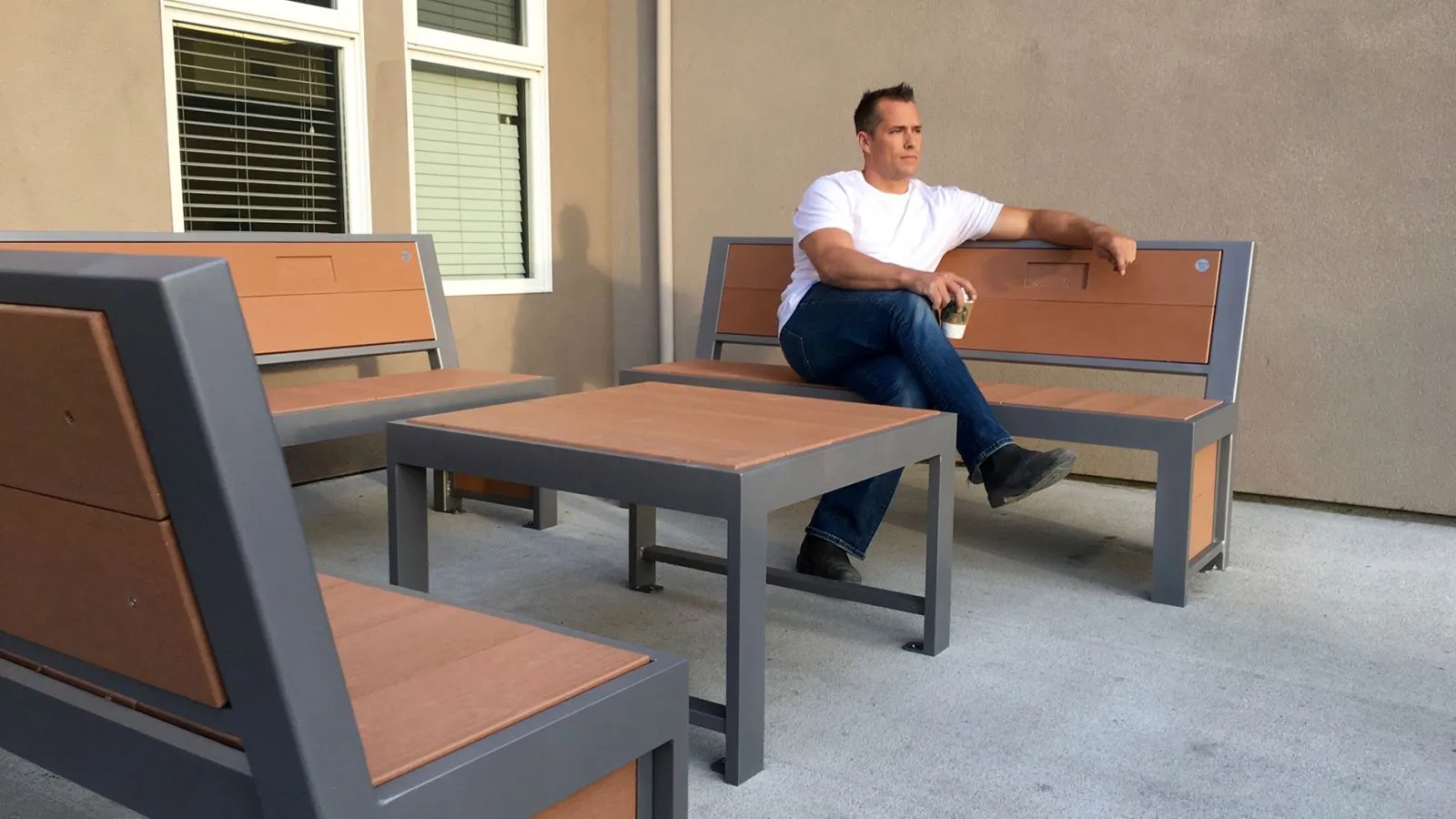 Urban Form benches and coffee table create a comfortable outdoor seating area. The furniture features recycled plastic lumber and powder-coated metal frames.