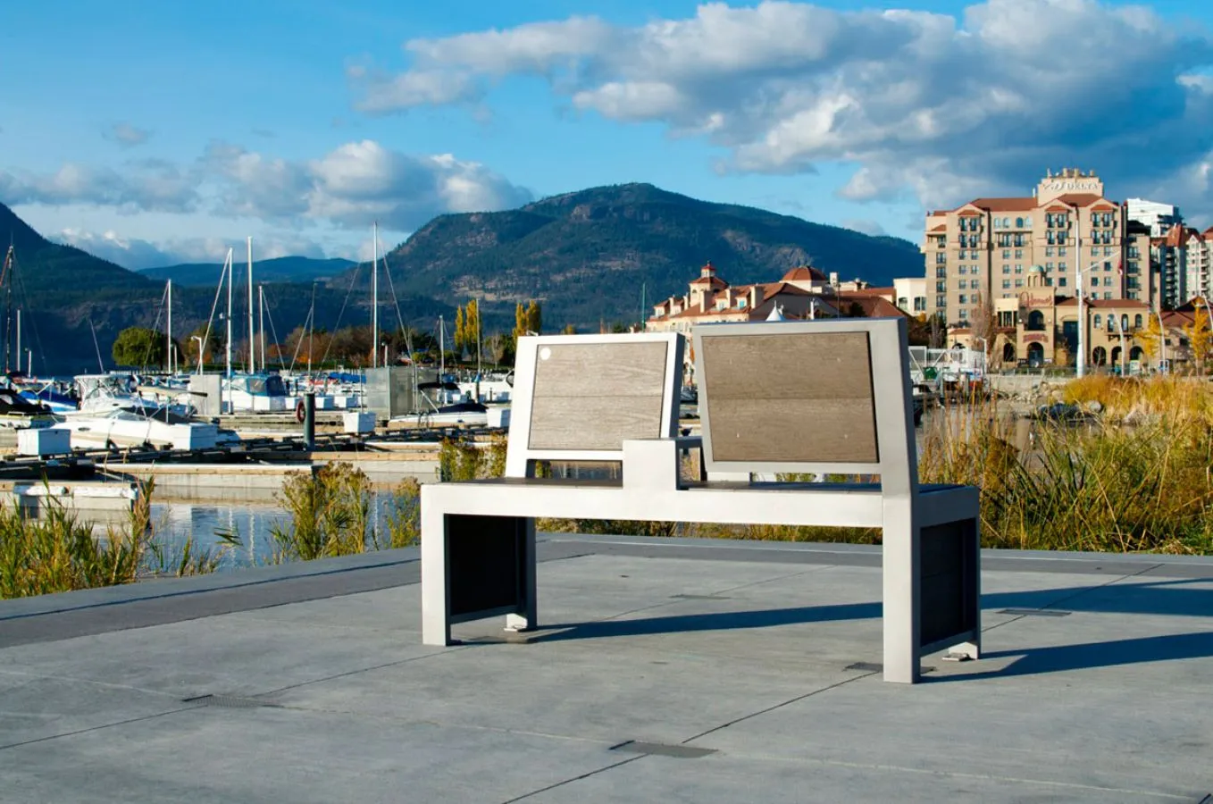 Urban Form Split Back Bench provides comfortable seating along a waterfront promenade. The bench features a powder-coated metal frame and recycled plastic lumber seat.