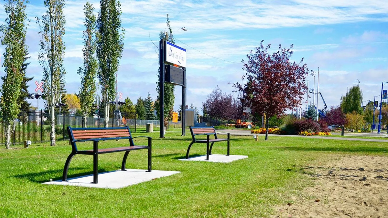 Two Beselt benches provide seating in Lions Legacy Park. The benches feature recycled plastic lumber and a powder-coated metal frame.