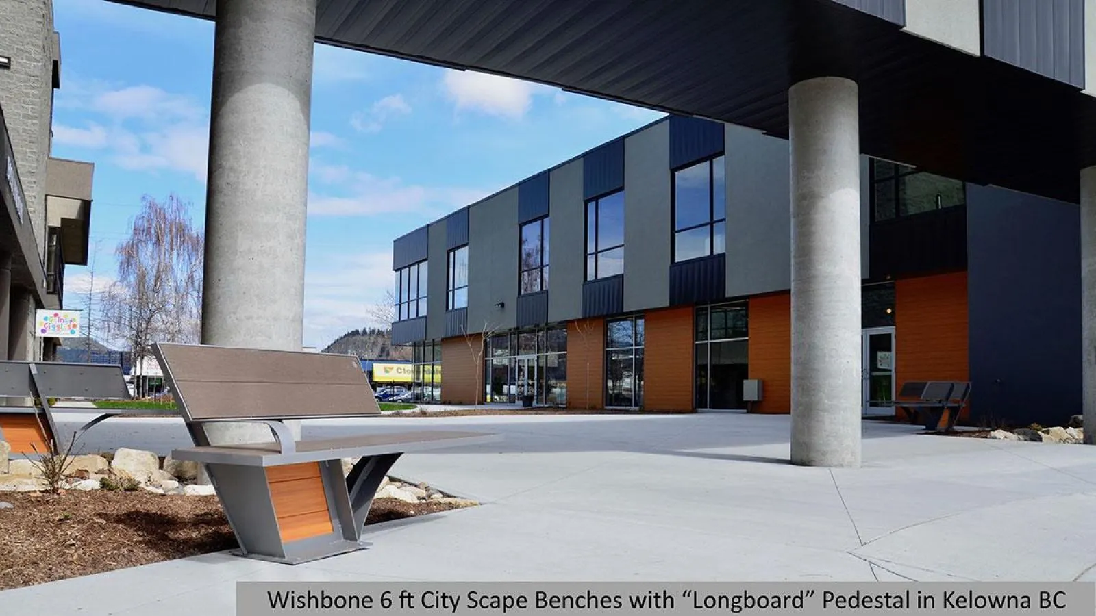 These City Scape benches with Longboard pedestals provide comfortable seating in an outdoor commercial space. The benches feature recycled plastic lumber and a powder-coated metal frame.