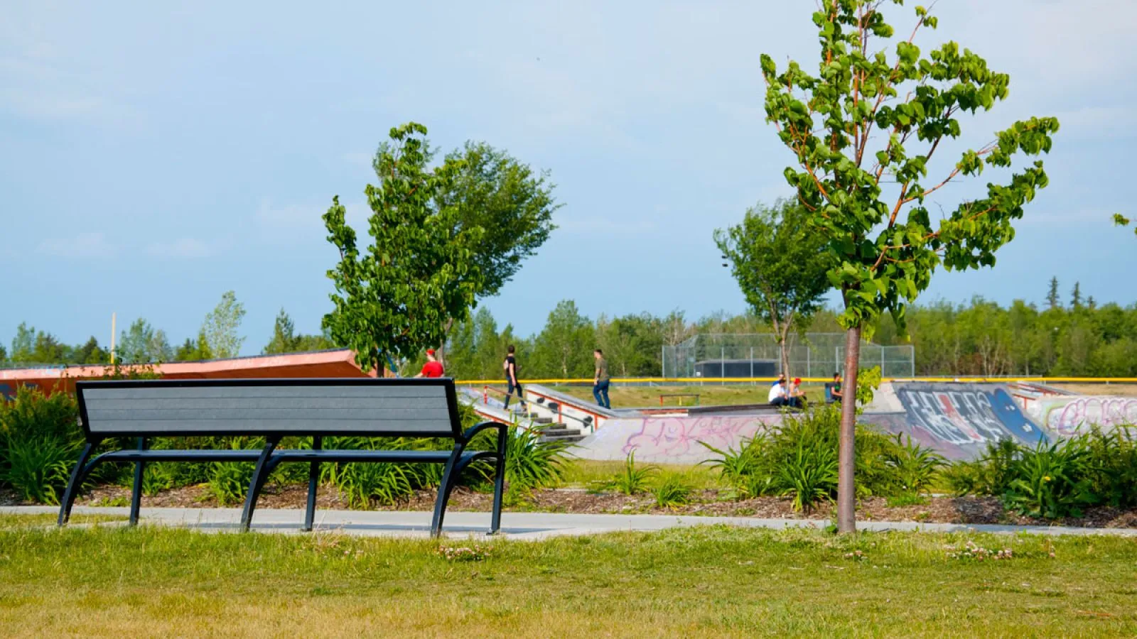 A Modena bench provides seating at the Callingwood Recreation Centre in Edmonton, Alberta. The bench features recycled plastic lumber and a powder-coated metal frame.