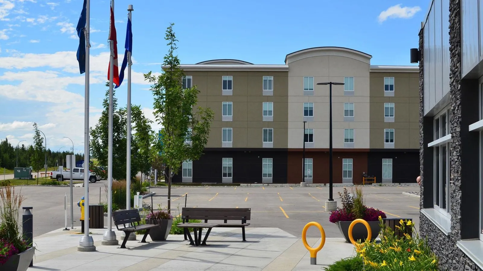 Bayview benches and a West End waste receptacle provide seating and waste management at the Union of Healthcare Professionals in Edmonton, Alberta. The site furniture complements the building's architecture and landscaping.