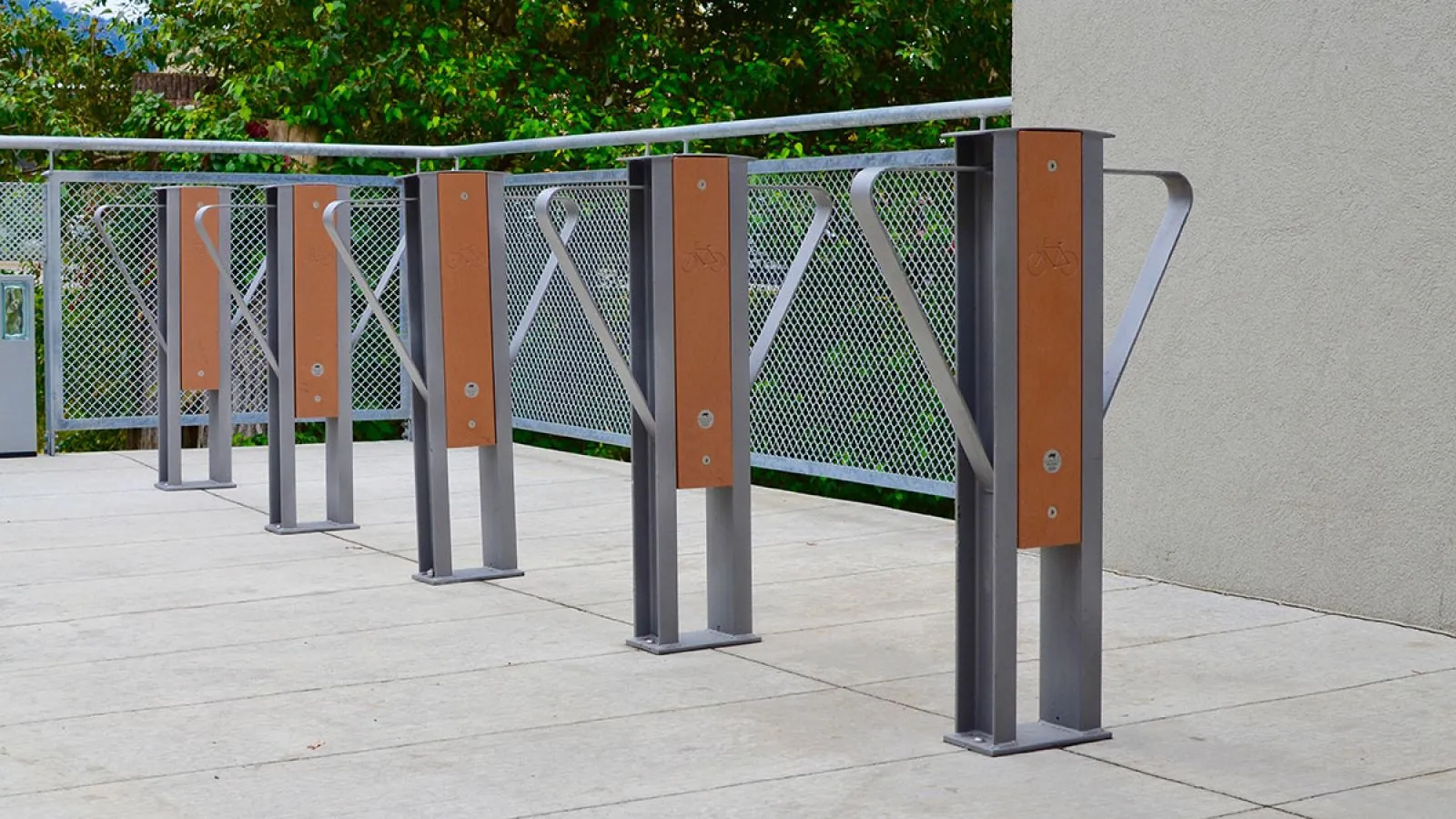 Beselt 2-space bike racks provide secure parking for cyclists. The racks feature recycled plastic lumber accents and a durable metal frame.