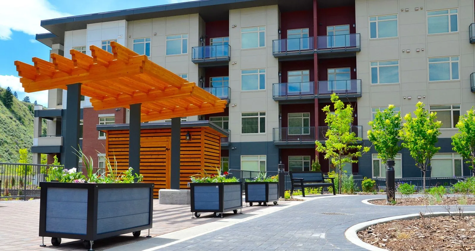 Mobile planter boxes add greenery to the outdoor patio area of The Residence at Orchards Walk in Kamloops, British Columbia. The planters feature recycled plastic lumber and powder-coated metal frames.