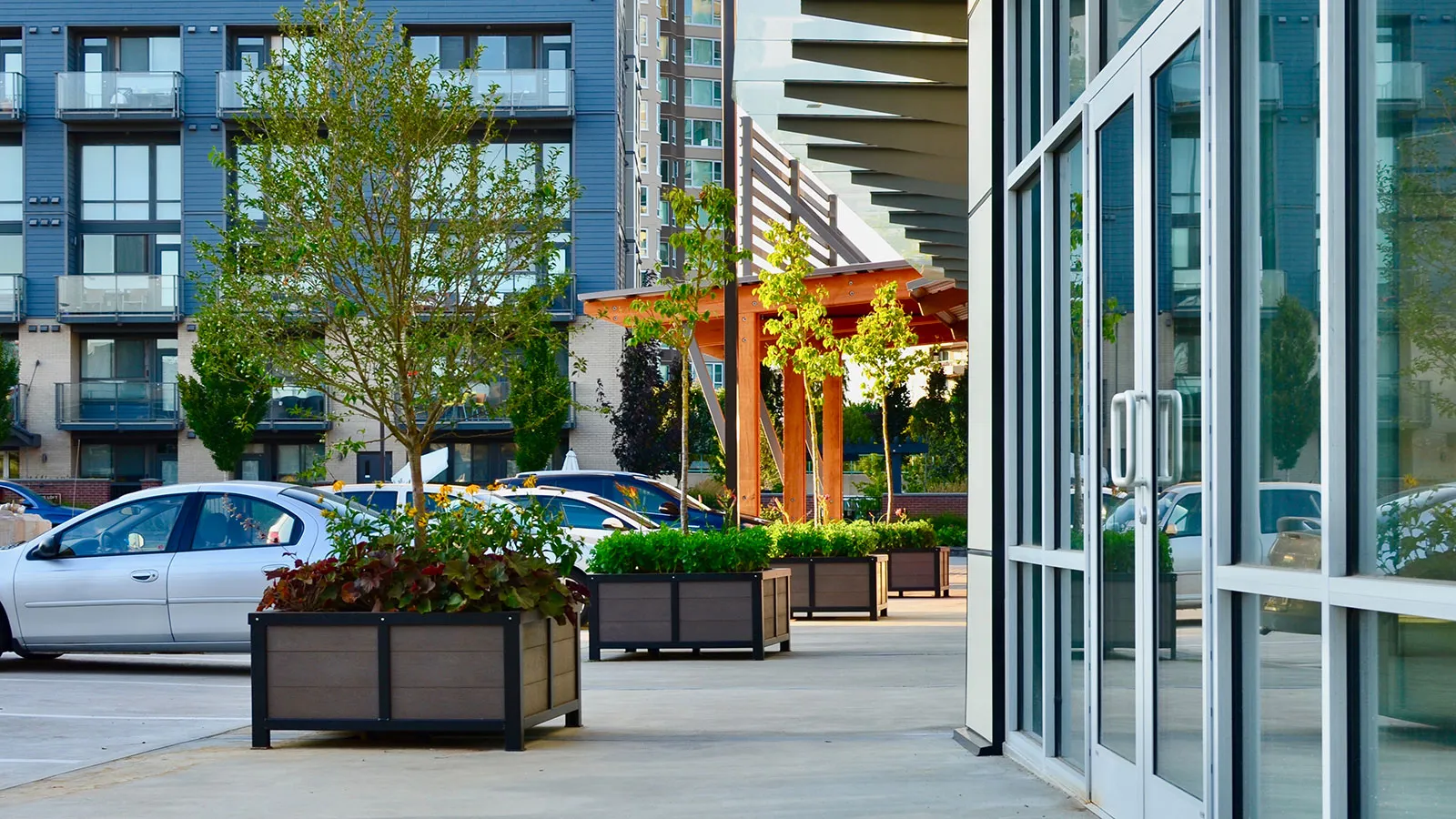 These Rutherford planters add greenery to a commercial space. The planters feature recycled plastic lumber and powder-coated metal frames.