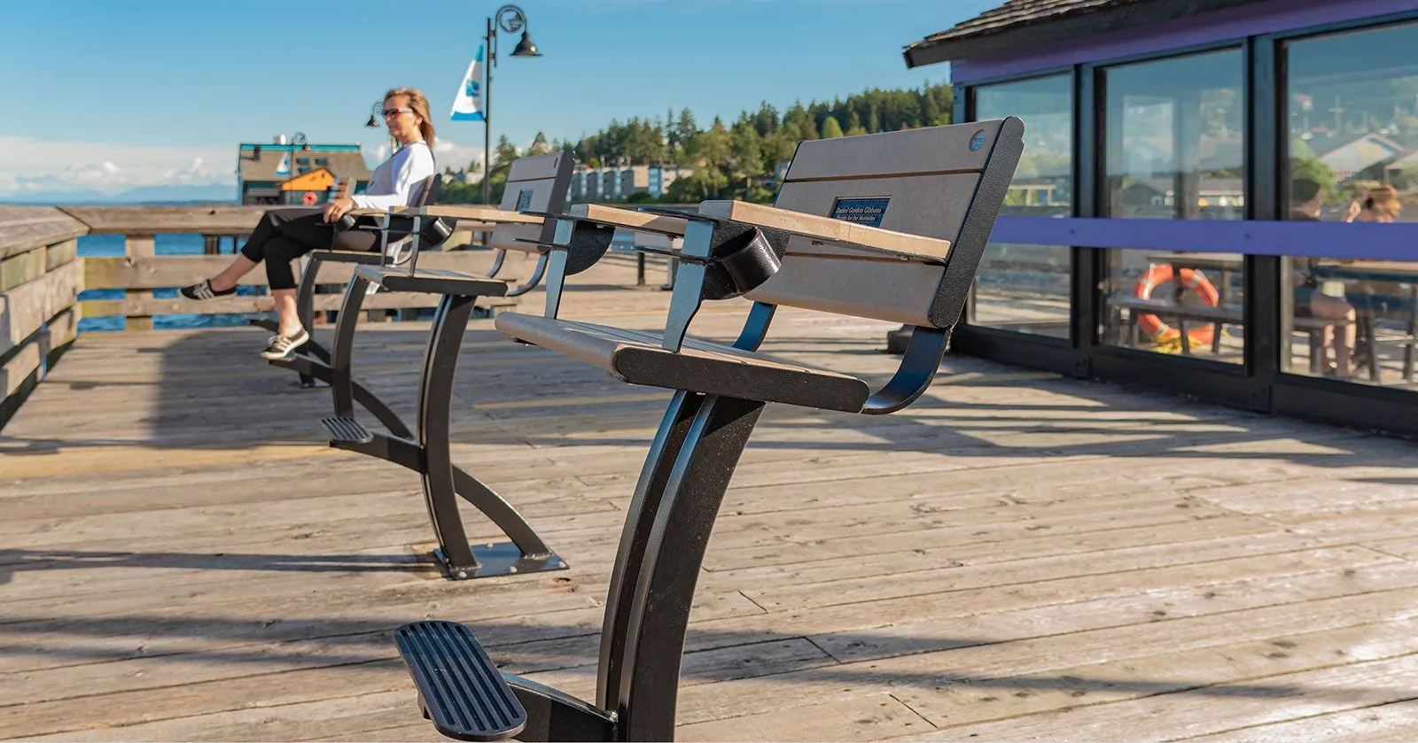 Parker Fisherman's Chairs provide comfortable seating on a wooden pier overlooking the water. The chairs feature recycled plastic lumber and powder-coated metal frames.