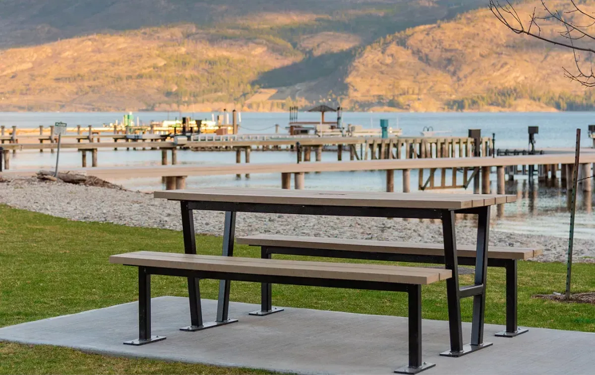 A Rutherford Picnic Table provides seating near the waterfront. The table features recycled plastic lumber and a powder-coated metal frame.