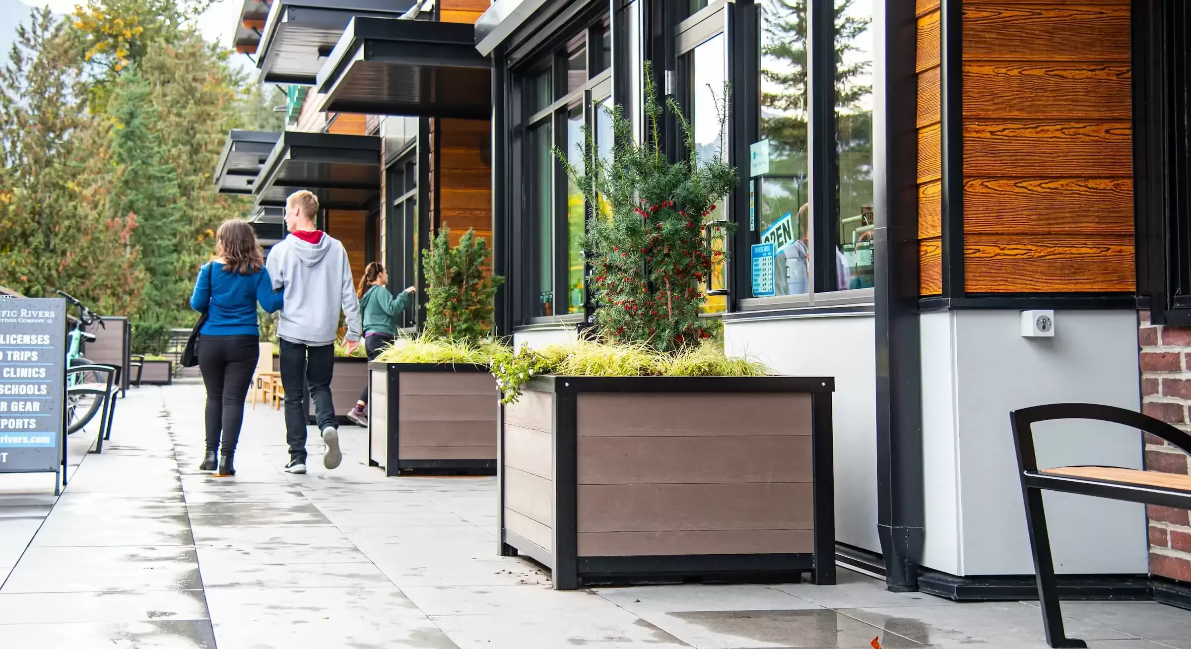 These self-watering square planters add greenery and visual interest to a commercial space. The planters feature recycled plastic lumber and a powder-coated metal frame.