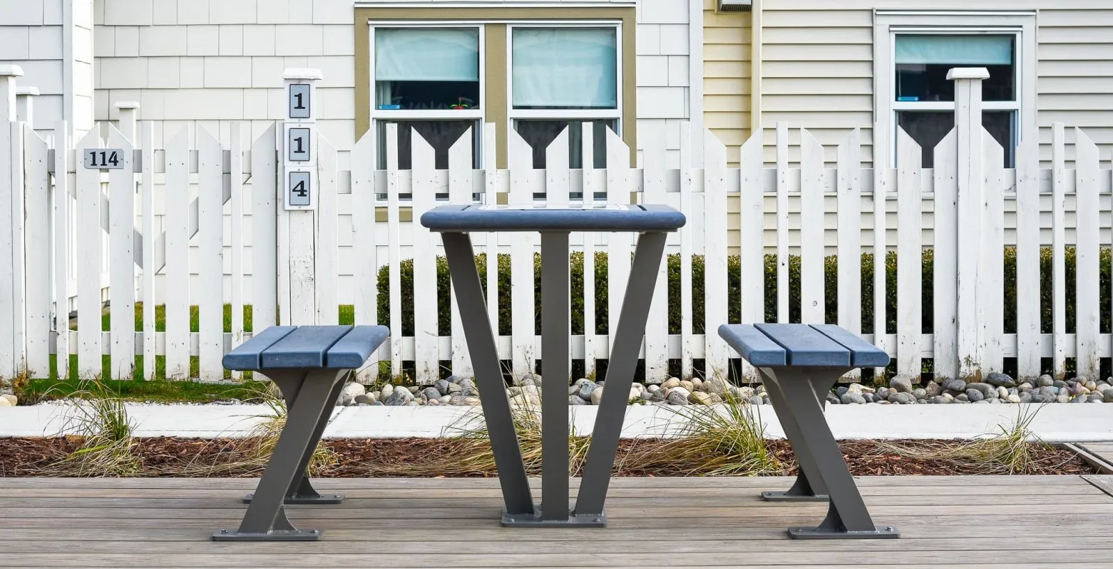 Bayview Games Coffee Table with attached benches provides a place for outdoor chess or checkers. The table and benches feature recycled plastic lumber and a powder-coated metal frame.