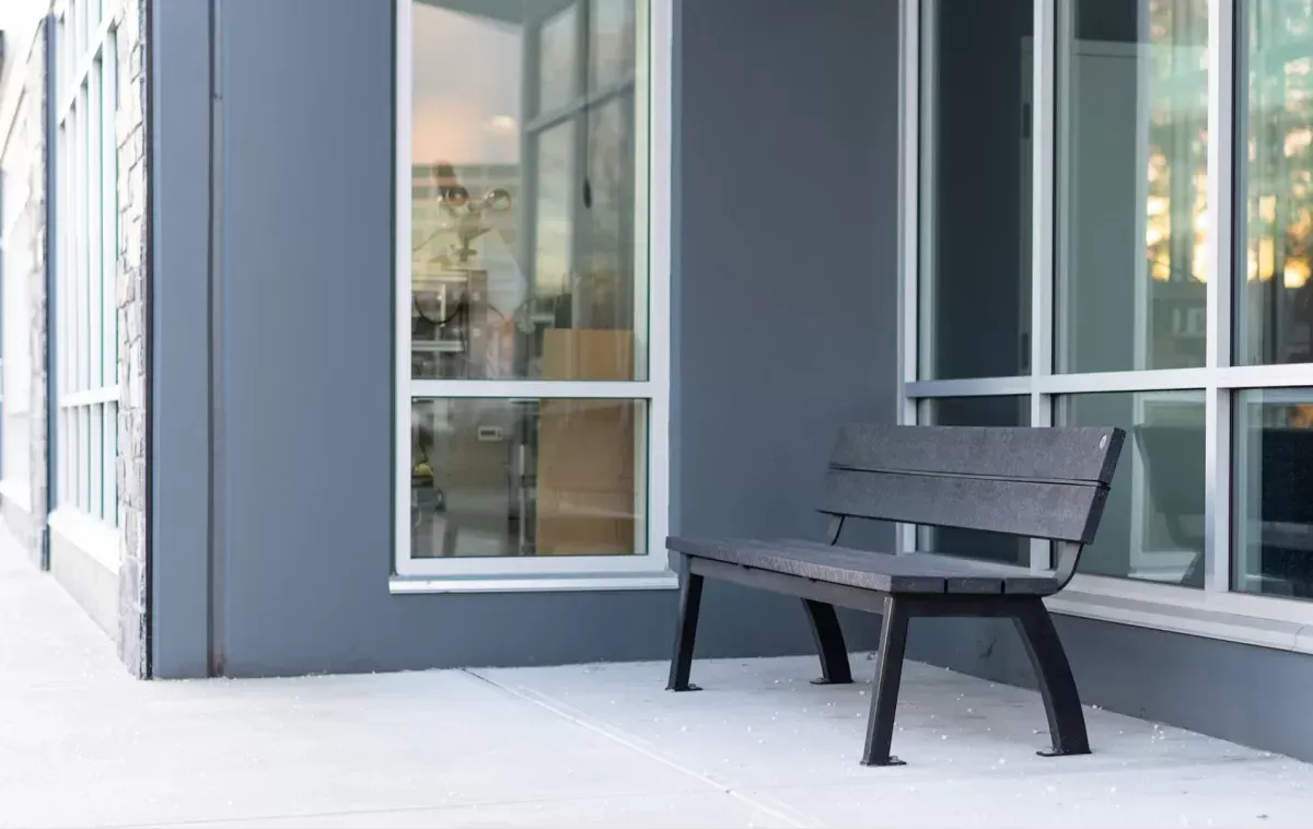 Aylesbury bench with recycled plastic lumber seating and black powder-coated metal frame. This bench provides comfortable outdoor seating.
