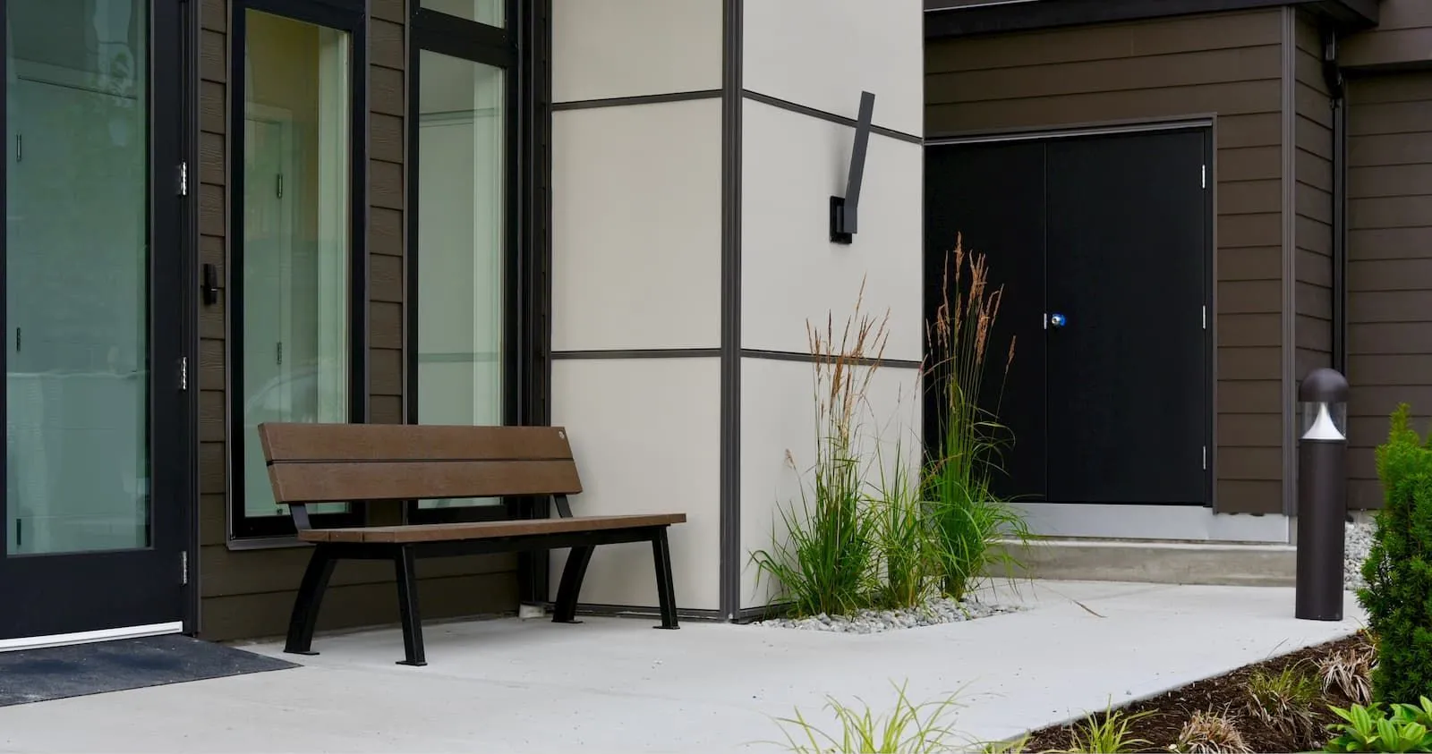 Aylesbury bench with recycled plastic lumber seating and powder-coated metal frame. This bench provides comfortable seating in a modern outdoor setting.