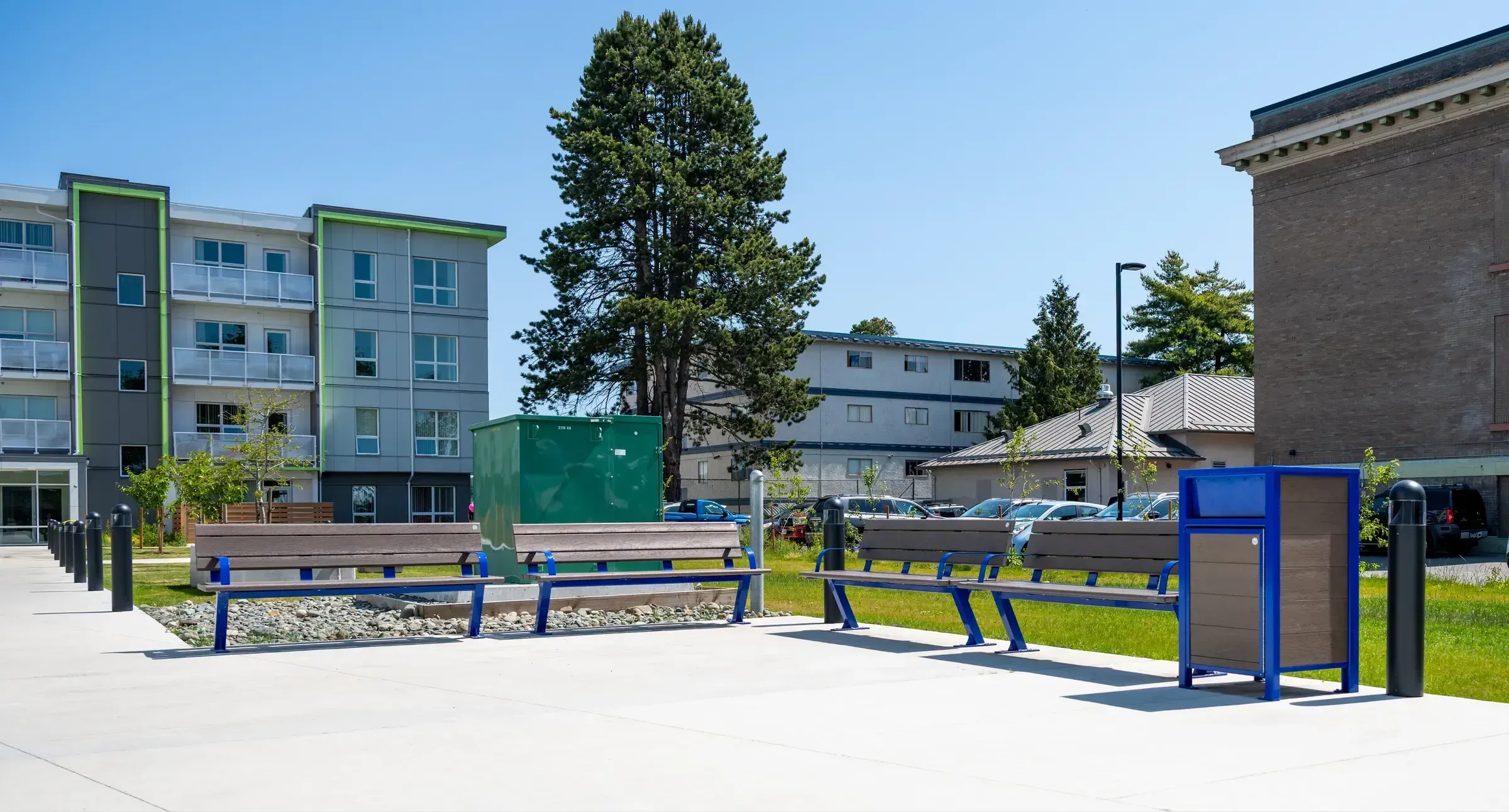 Bayview benches and an Urban Form waste receptacle provide seating and waste disposal at The Ferns Affordable Housing Complex in Victoria, British Columbia. The site furniture complements the modern architecture and landscaping.