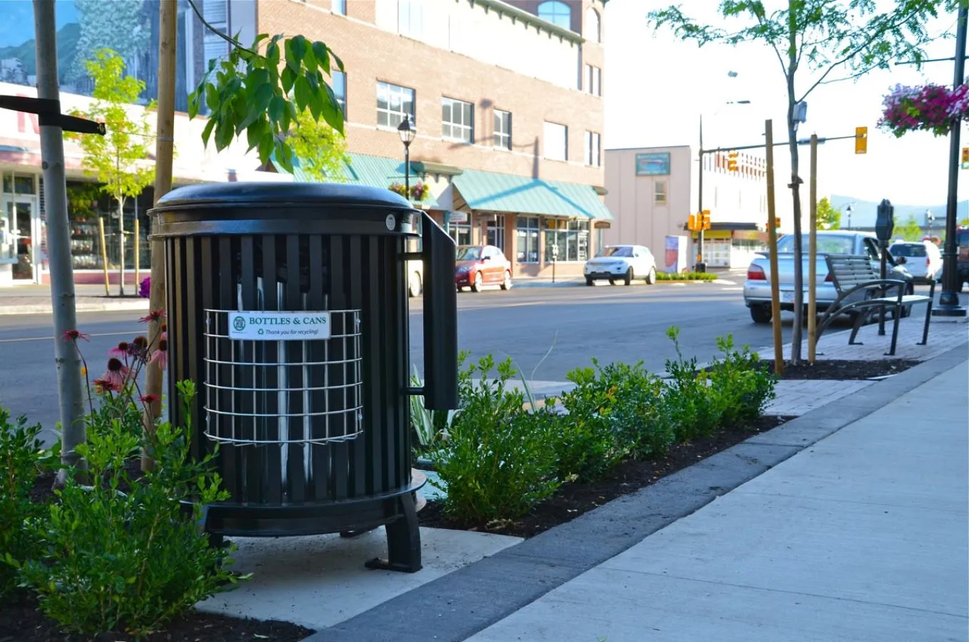 Beselt round waste receptacle with bottle and can recycling attachment and cigarette receptacle, powder coated in black. This durable and attractive bin is perfect for high-traffic areas.