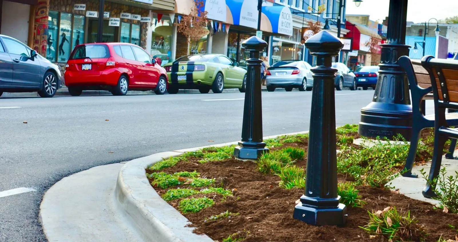 Classic bollards line a landscaped median strip in Mission, British Columbia. These bollards provide pedestrian safety and enhance the streetscape.