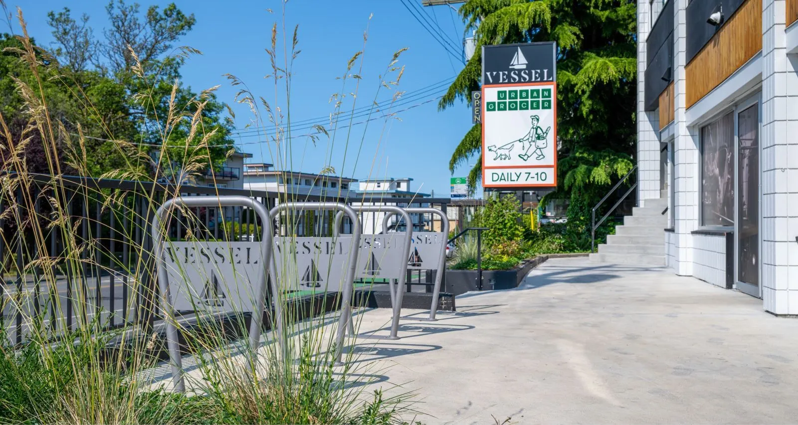 These 2-space bike racks provide convenient parking outside Vessel Urban Grocery. The racks feature a modern design with the store's name cut into the metal.