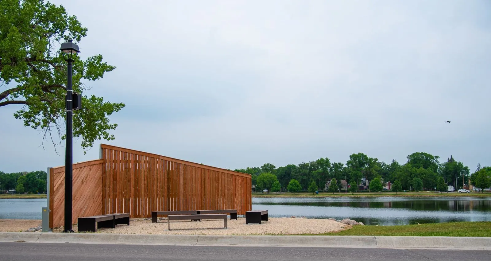 Hutch Backless Benches provide seating along a waterfront pathway. The benches feature black recycled plastic lumber and a simple, modern design.