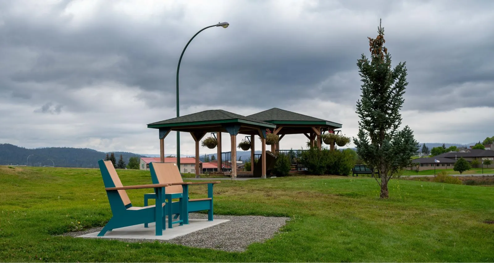 Two JEM Lounge Chairs and a JEM Side Table provide a relaxing seating area in Maggs Park. The chairs feature a two-tone design with recycled plastic lumber and powder-coated metal frames.