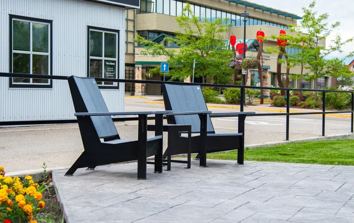 Two JEM Lounge Chairs and a JEM Side Table create a relaxing outdoor seating area. The chairs feature recycled plastic lumber and powder-coated frames.
