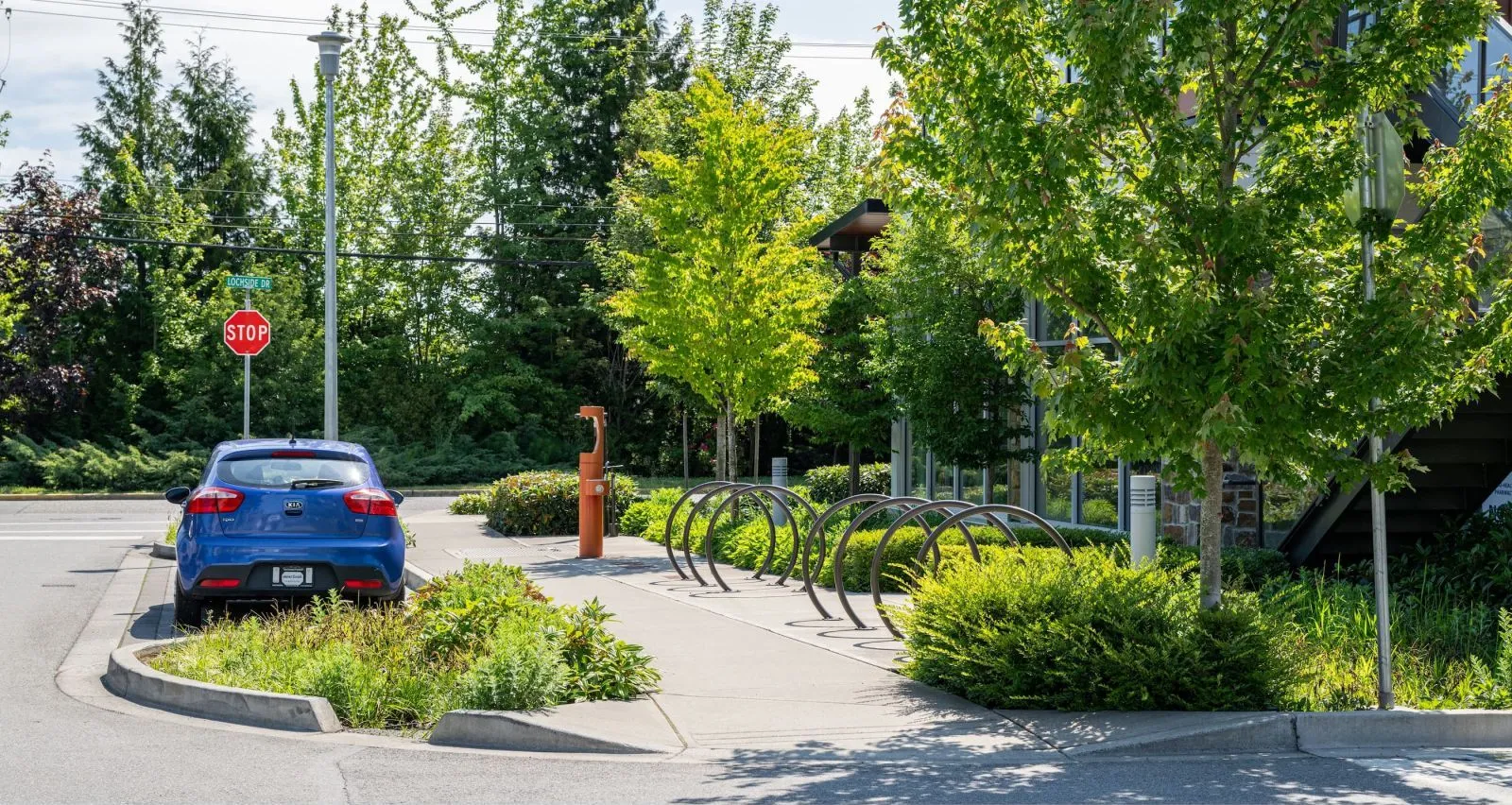 Durable LOOP bike racks provide convenient parking at a commercial building. The bike racks are powder coated in orange.