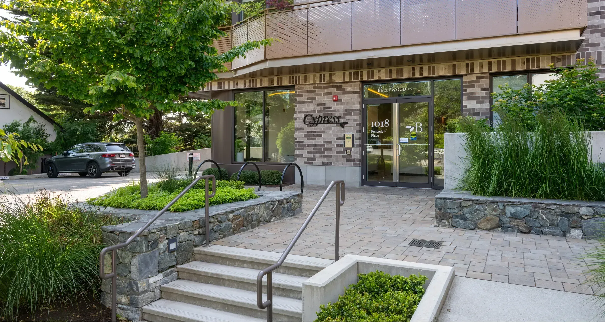Bike racks provide convenient parking outside the Cypress building at Bellewood Park in Victoria, British Columbia. The black loop racks complement the building's modern design.