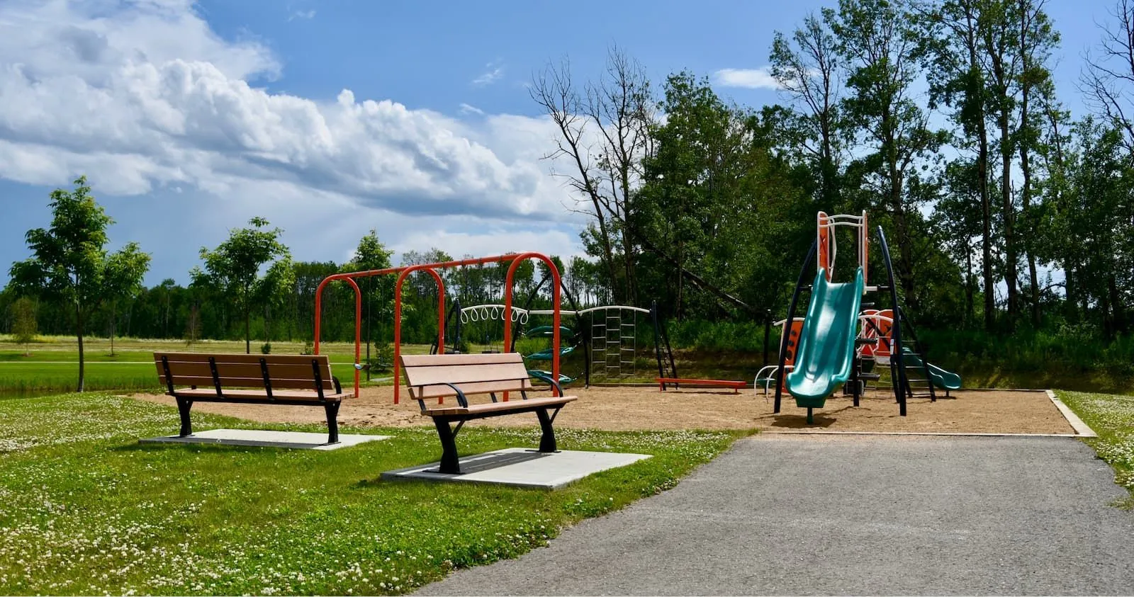 Durable benches provide seating near a playground. These benches offer a comfortable place to rest while enjoying the outdoor space.