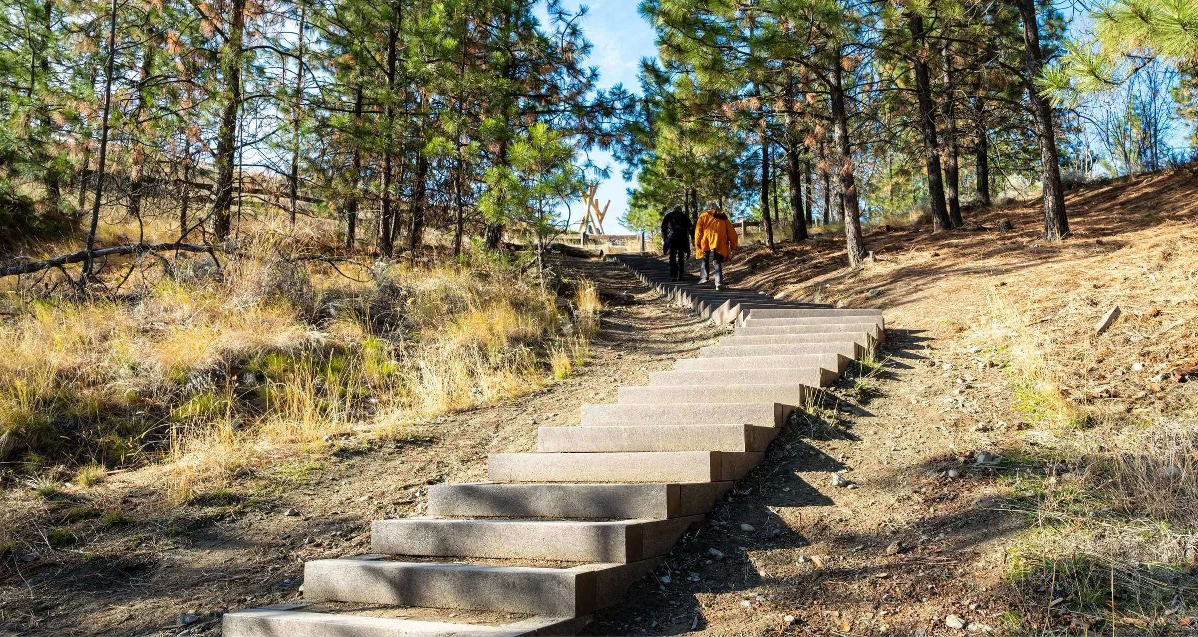 Durable steps provide access on a hillside trail. These steps are made from recycled plastic lumber and powder-coated metal.