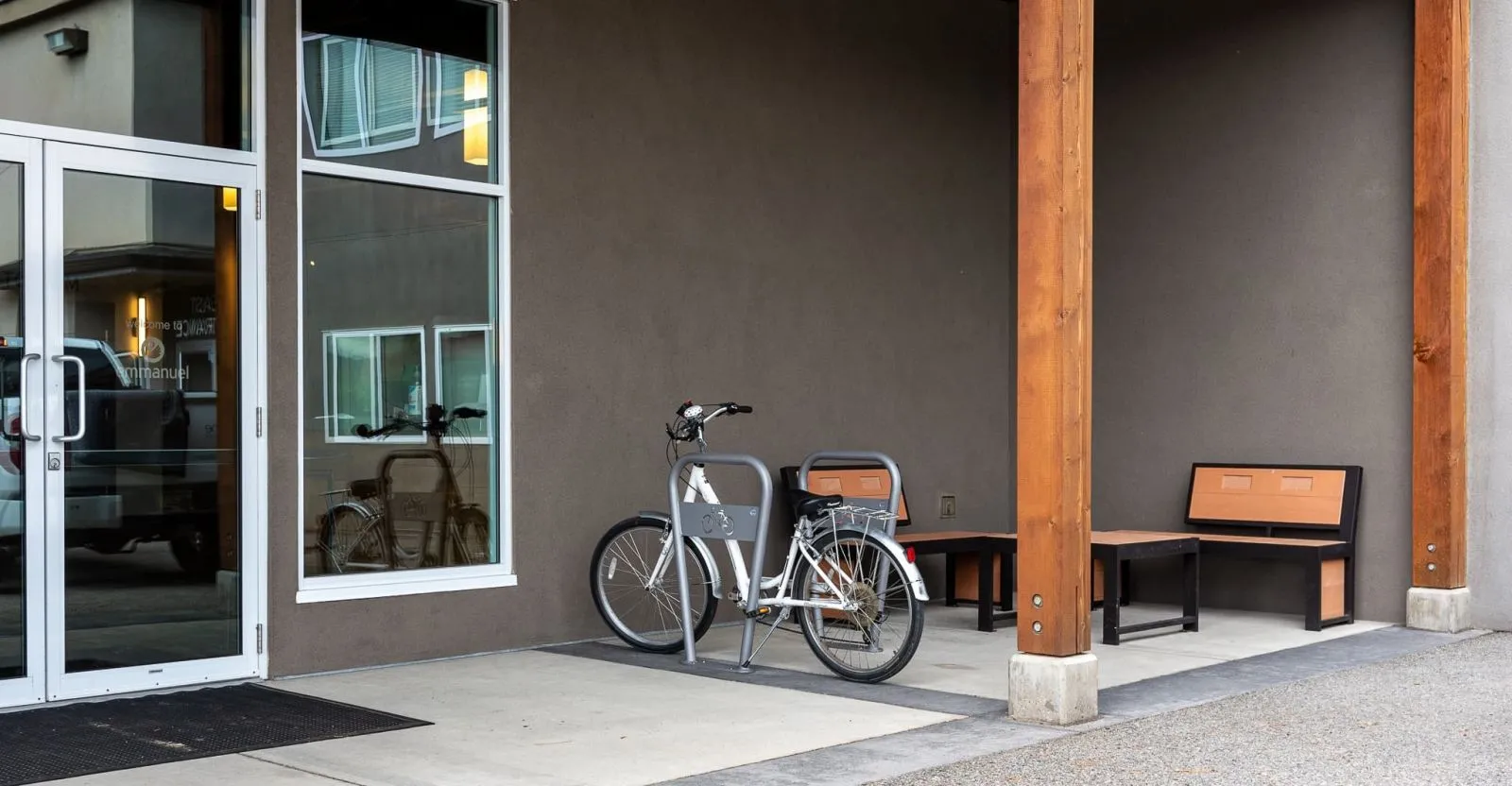 Two-space bike rack installed outside Emmanuel Church in West Kelowna, BC. The bike rack is silver and sits on a concrete pad.