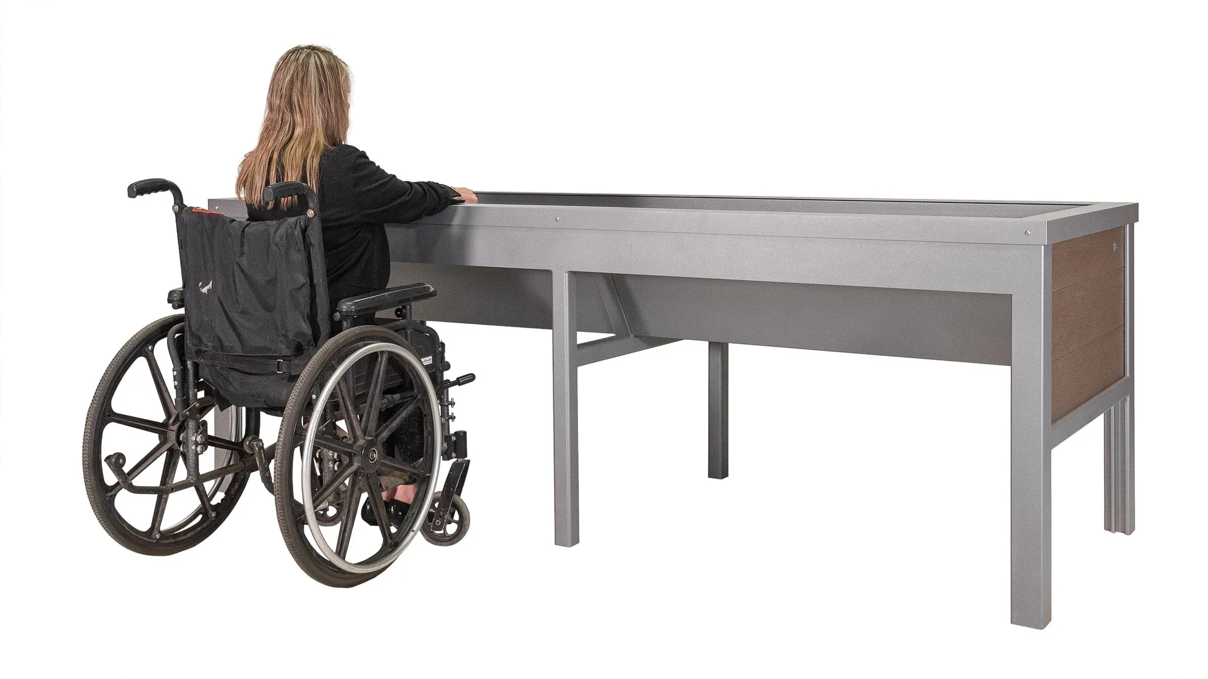 Wheelchair-accessible planter with a user in a wheelchair. The planter features a metal frame and recycled plastic lumber panels.