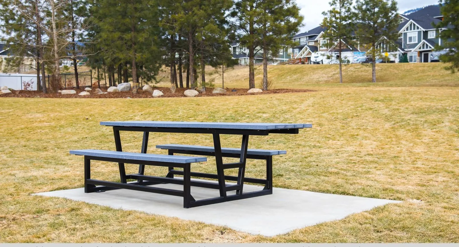 Wheelchair accessible heavy-duty picnic table provides an inclusive outdoor dining space. The table features a black frame and grey recycled plastic lumber.
