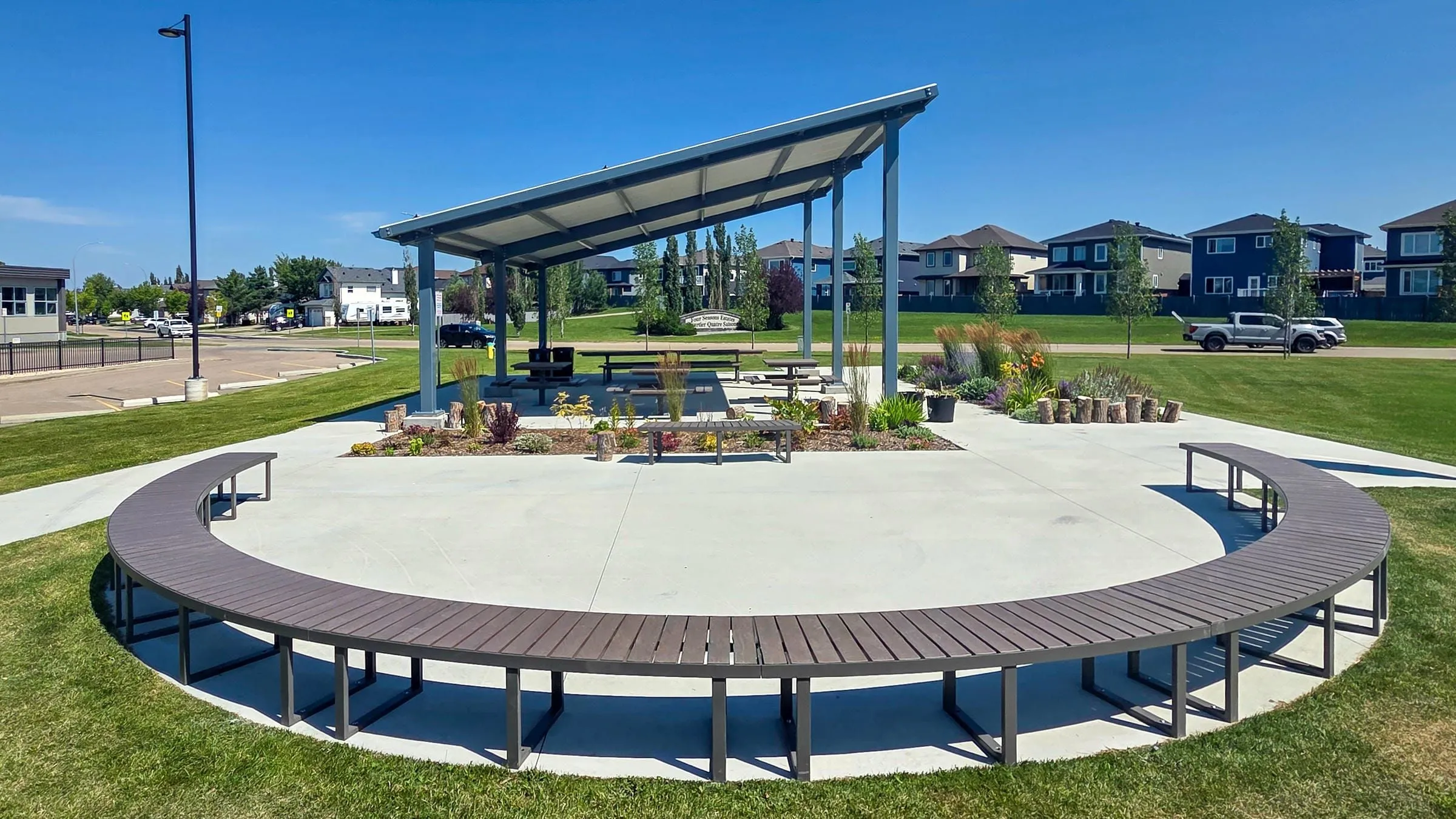 Curved park bench made with recycled plastic lumber and powder-coated metal frame. This bench provides comfortable seating in a public park setting.