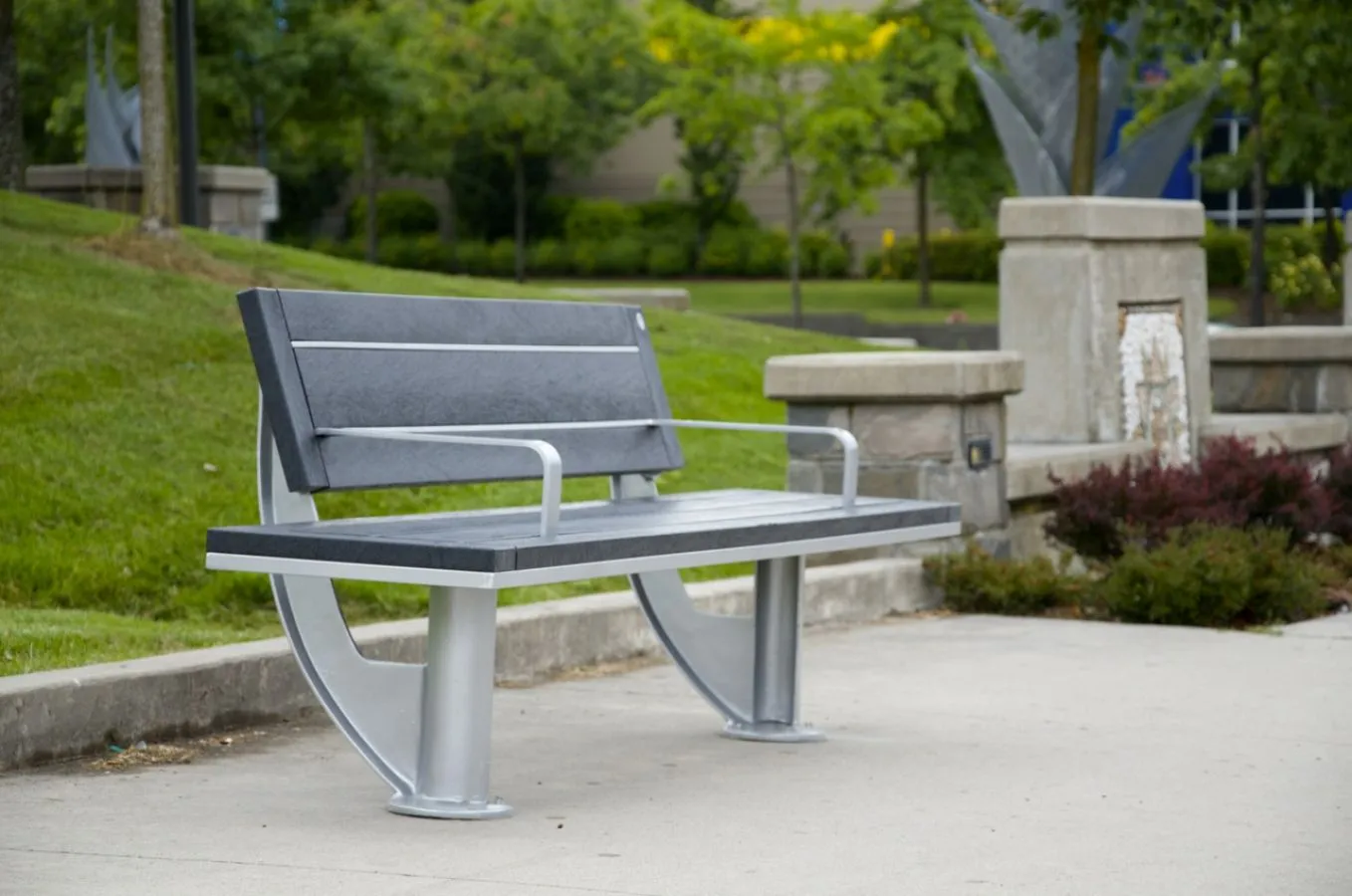 SurRe park bench with recycled plastic lumber and powder-coated metal frame. This bench provides comfortable seating in outdoor public spaces.