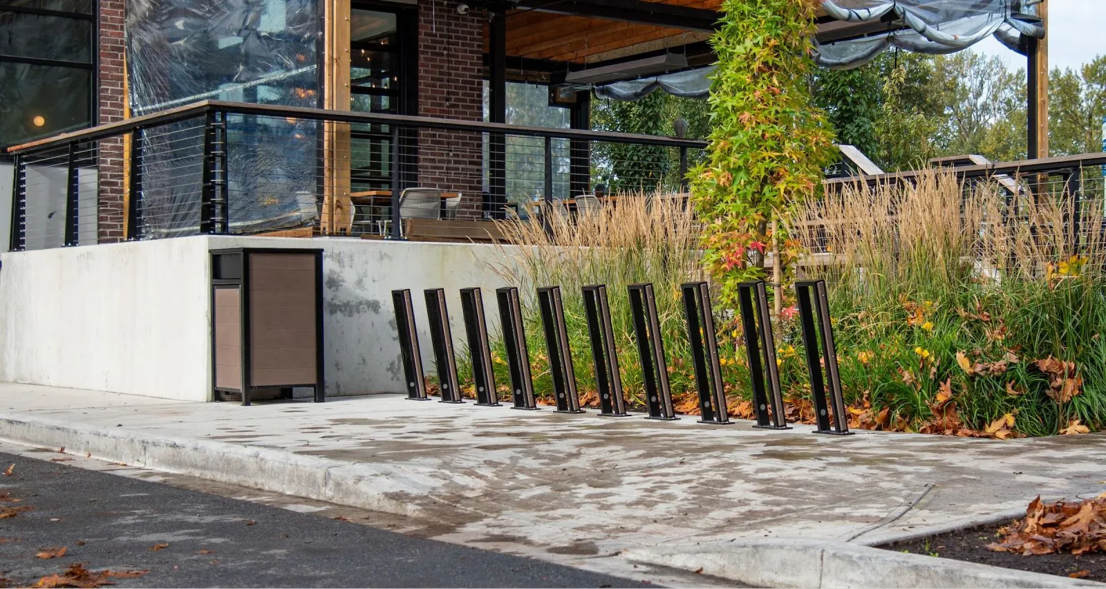 Bike racks provide convenient parking in a commercial setting. The site furniture complements the modern architecture and landscaping.