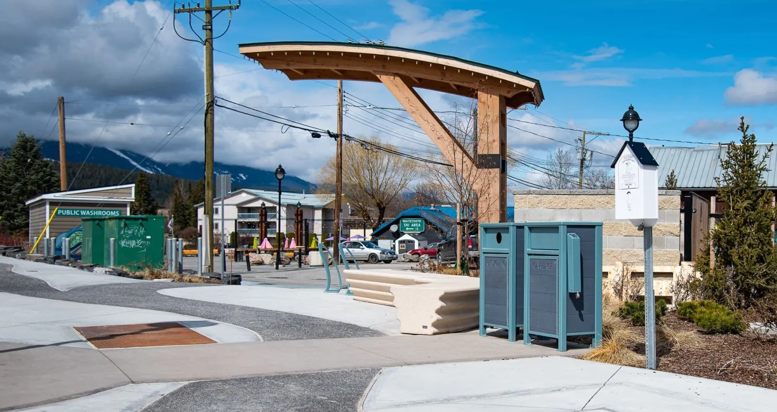 Urban Form Slim Line Waste Receptacles are powder-coated in a blue-grey finish, complementing the surrounding streetscape. These durable litter bins provide a convenient waste disposal solution for public spaces.