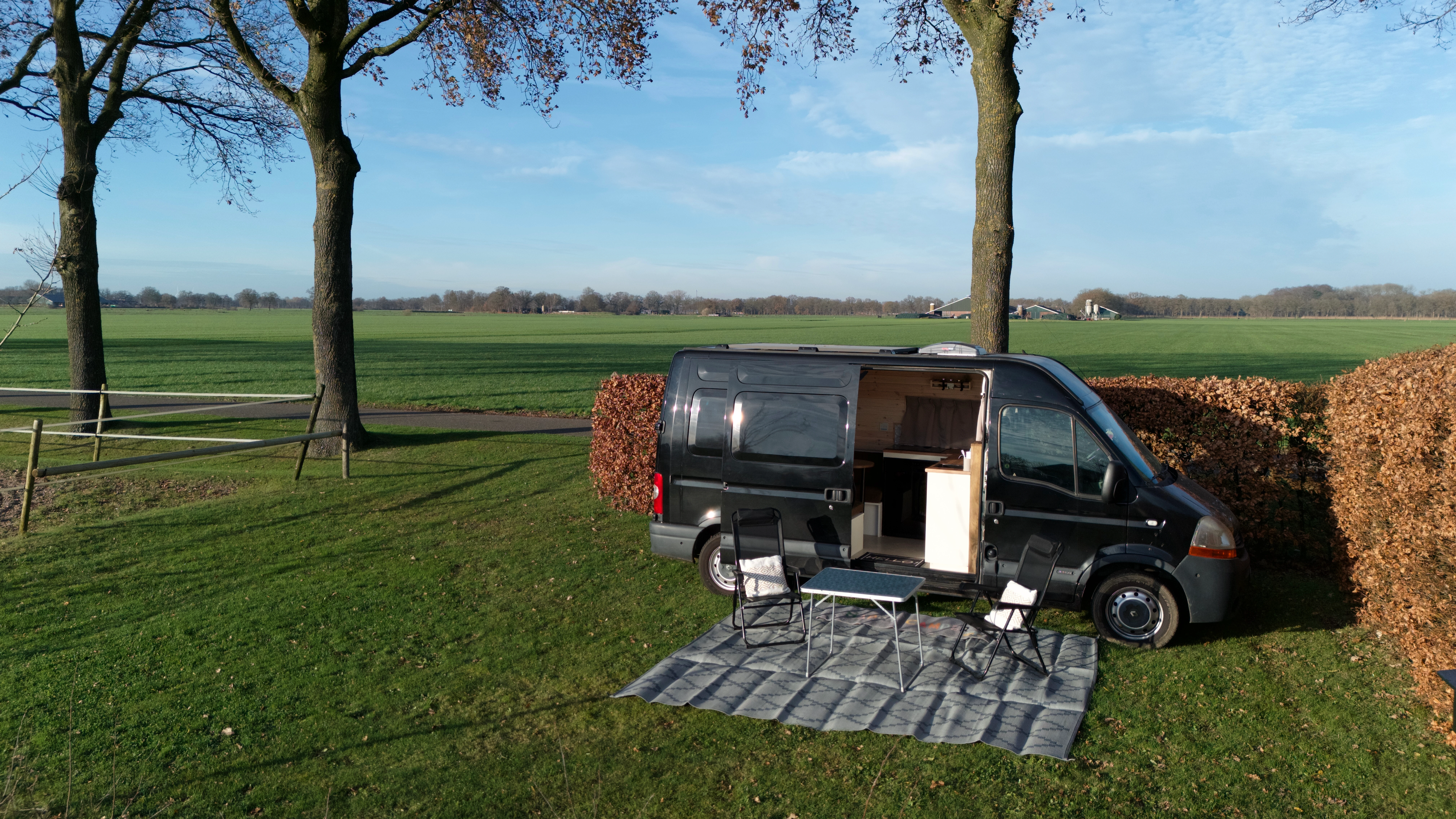 A camper van parked in a serene natural environment at dusk.