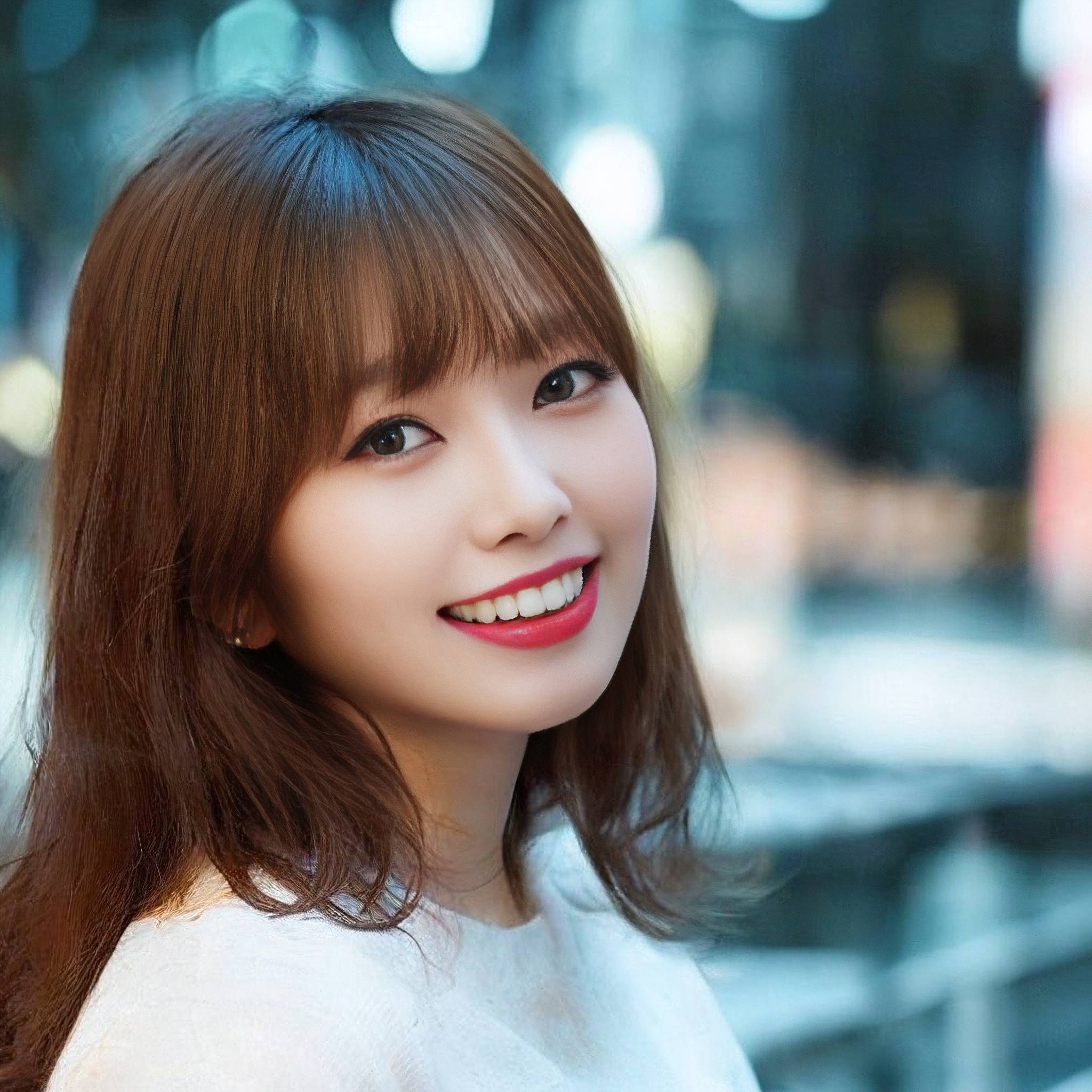 a woman in a white dress smiling at the camera 