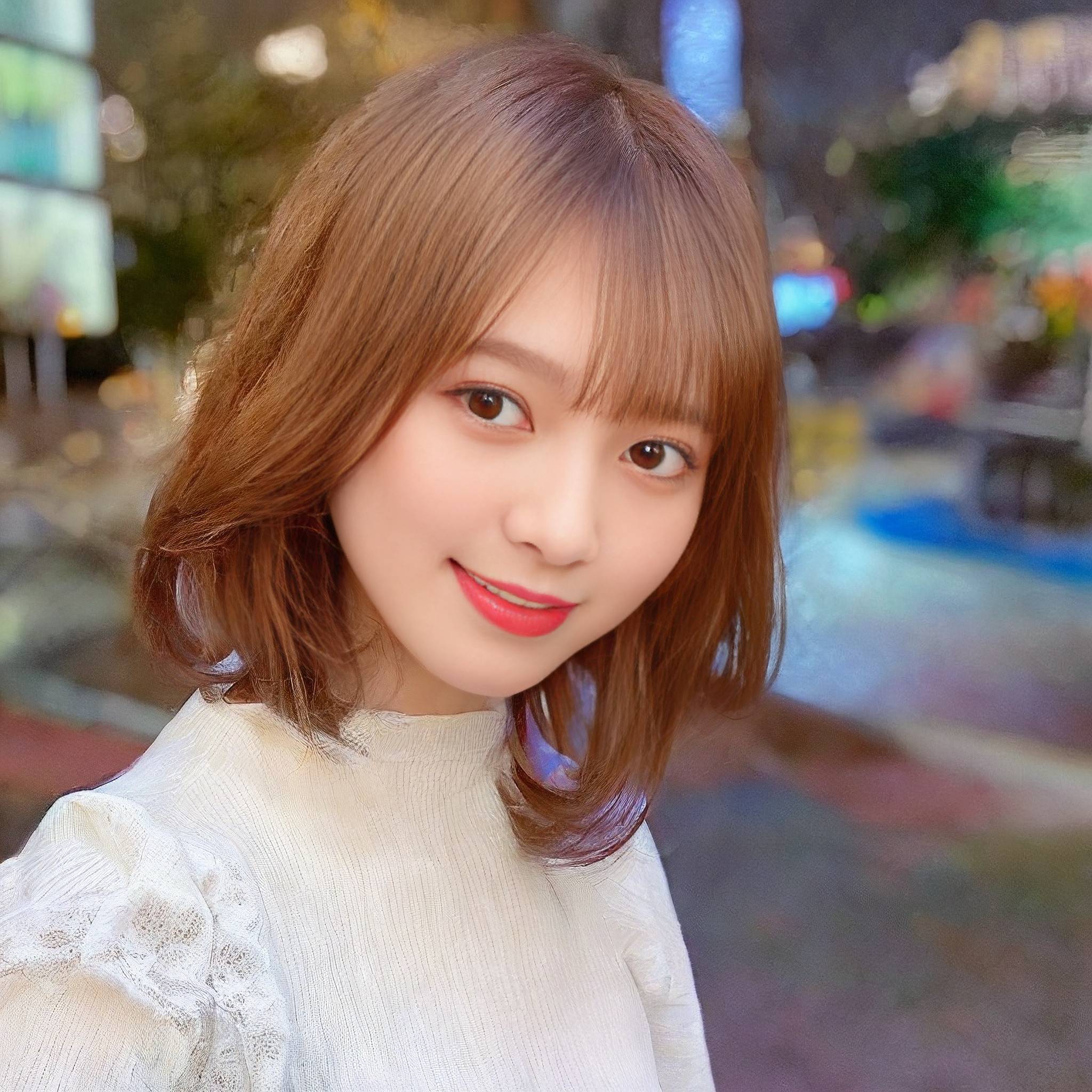 a woman with long hair standing in front of a building 