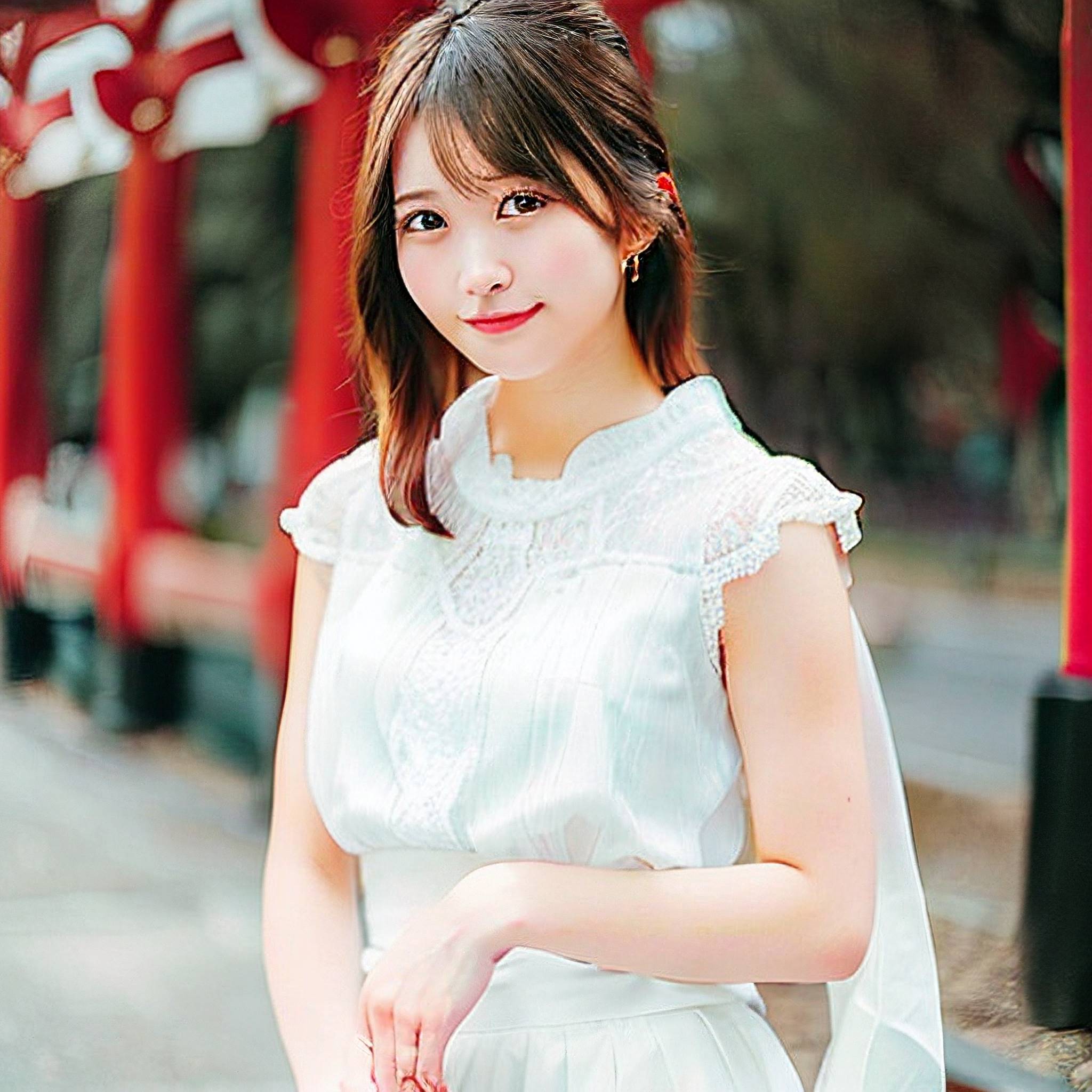 a woman in a white dress standing on a sidewalk 