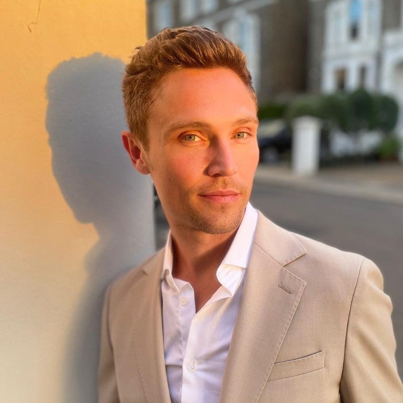 Jonathan Barry outdoors in a light suit