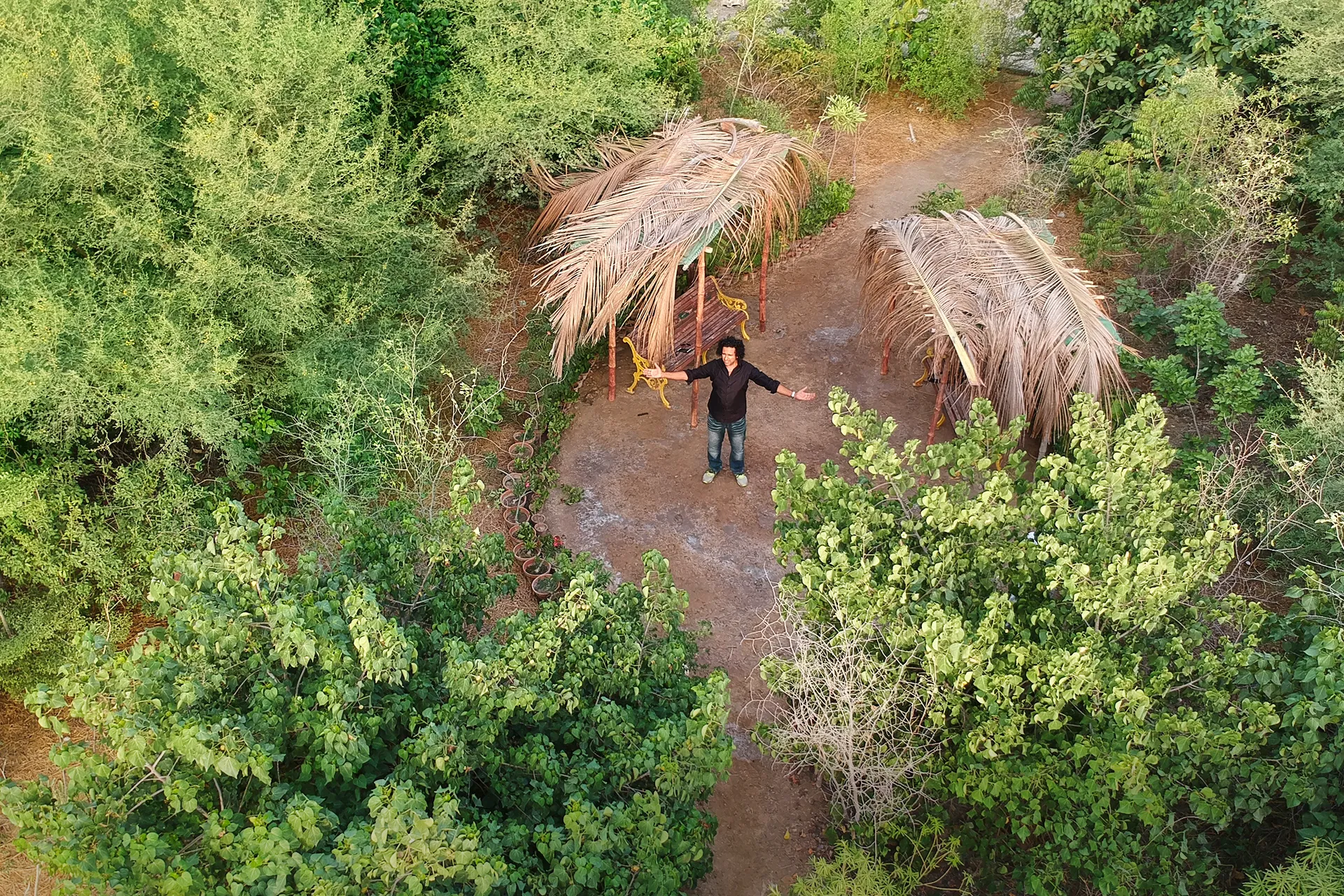 Shahzad Qureshi speaking at a podium in a blue blazer and pink tie