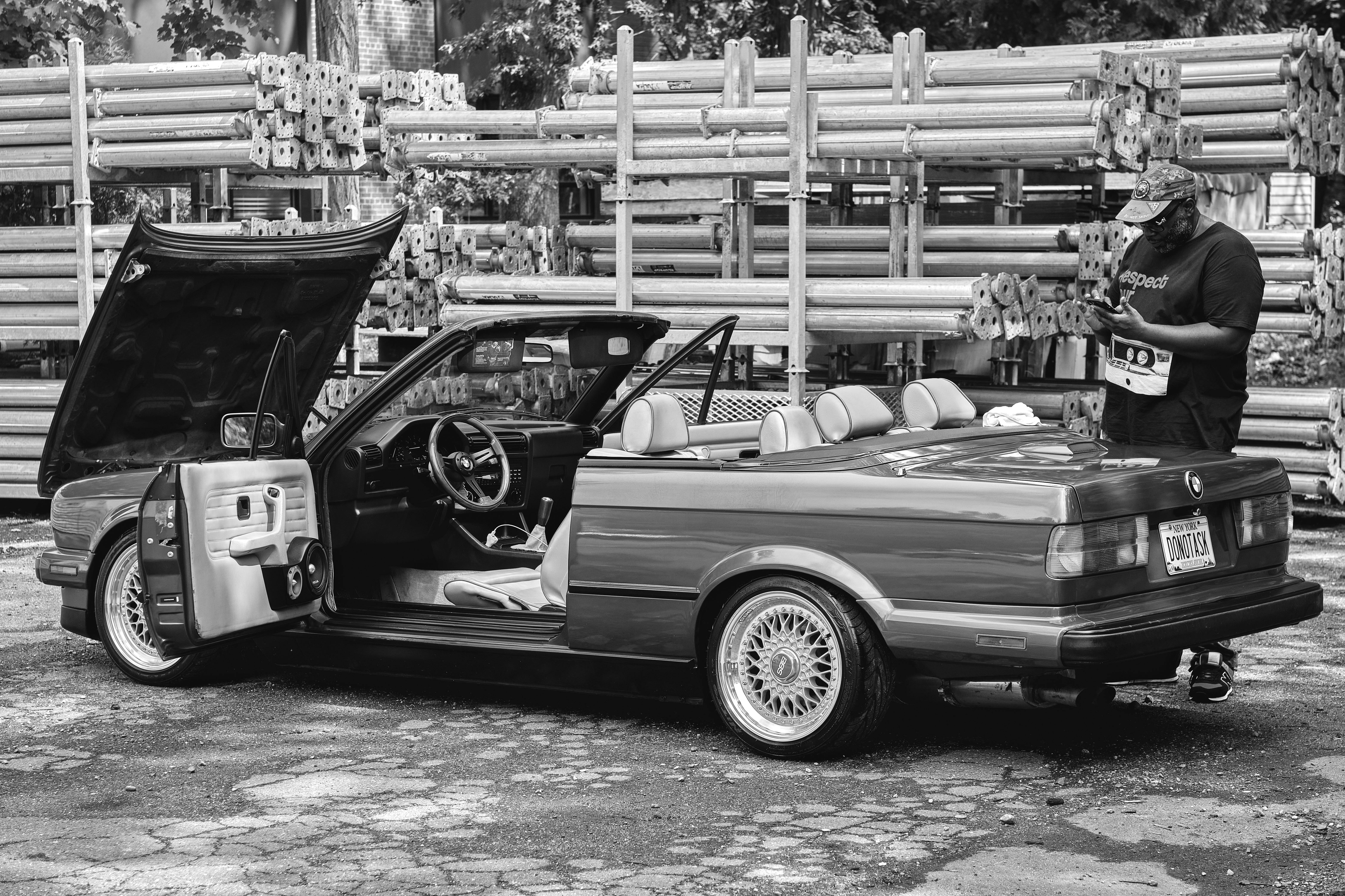 A photorealistic image of a professional contractor wearing a tool belt, examining the roof of a house with a flashlight in hand, focusing on a damage