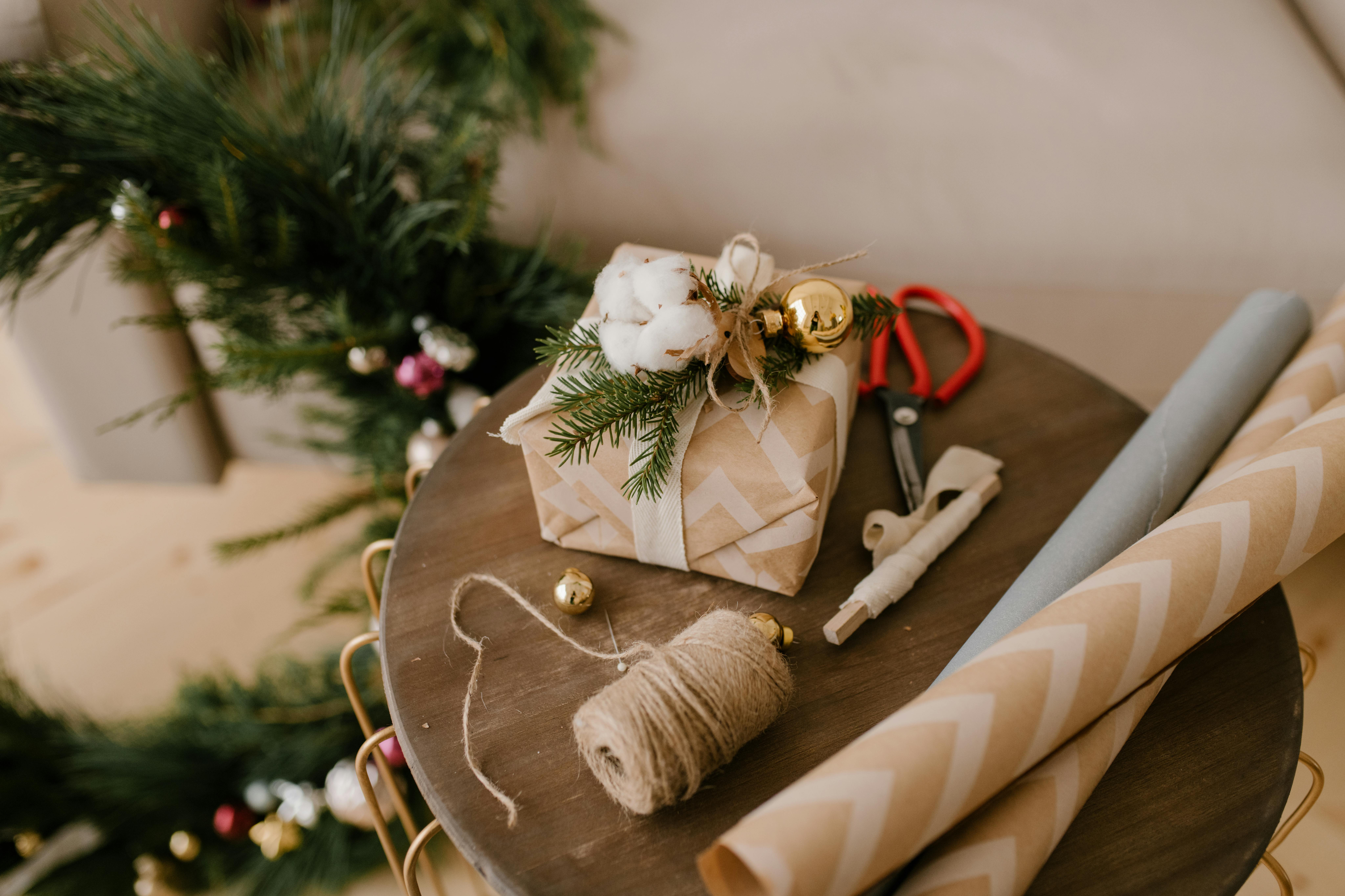 A collection of eco-friendly and safe holiday decorations displayed on a wooden table. The scene includes LED holiday lights, biodegradable ornaments,