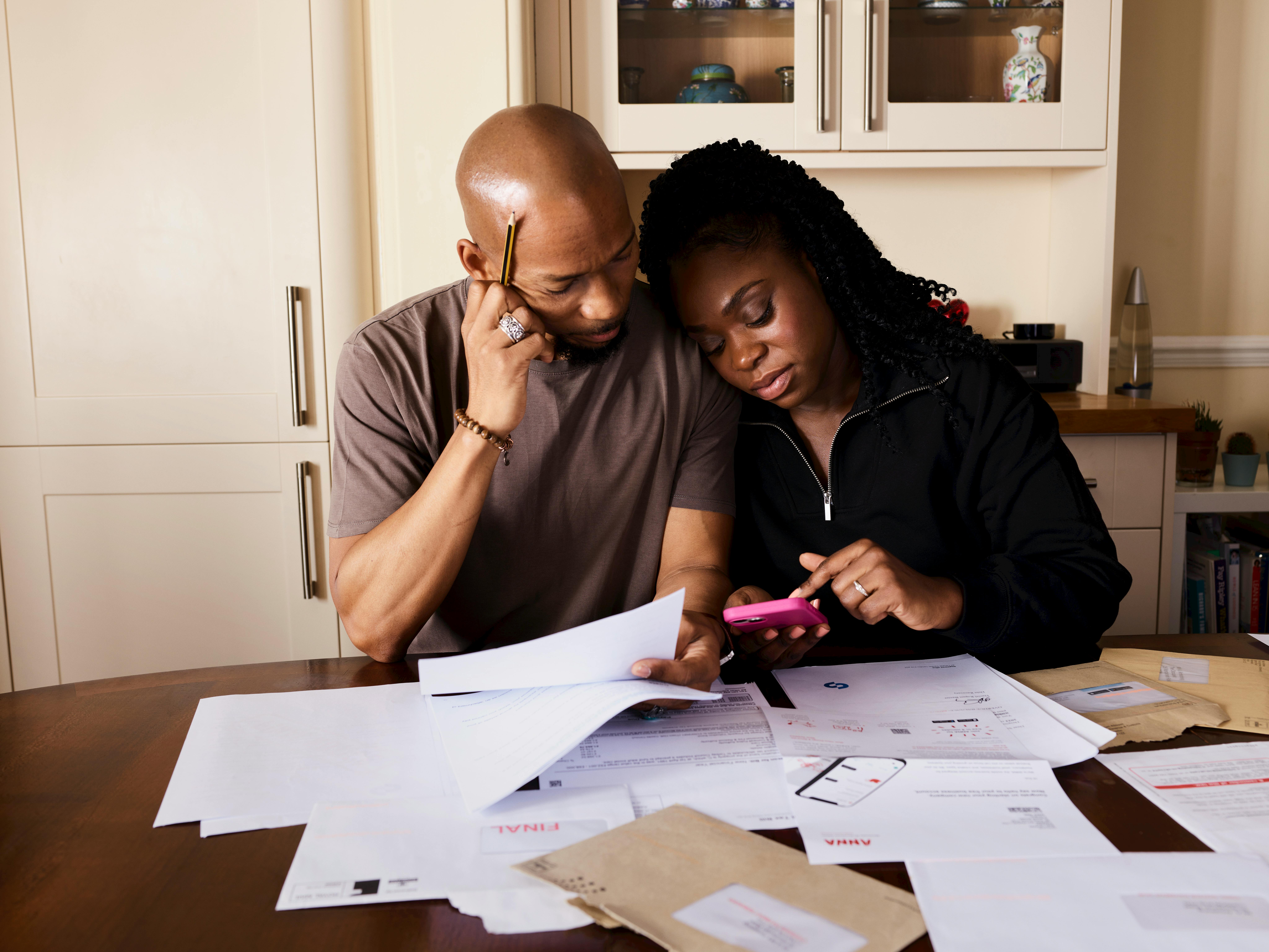A well-organized home renovation budget plan laid out on a home office desk. The plan includes spreadsheets open on a laptop, various financing option