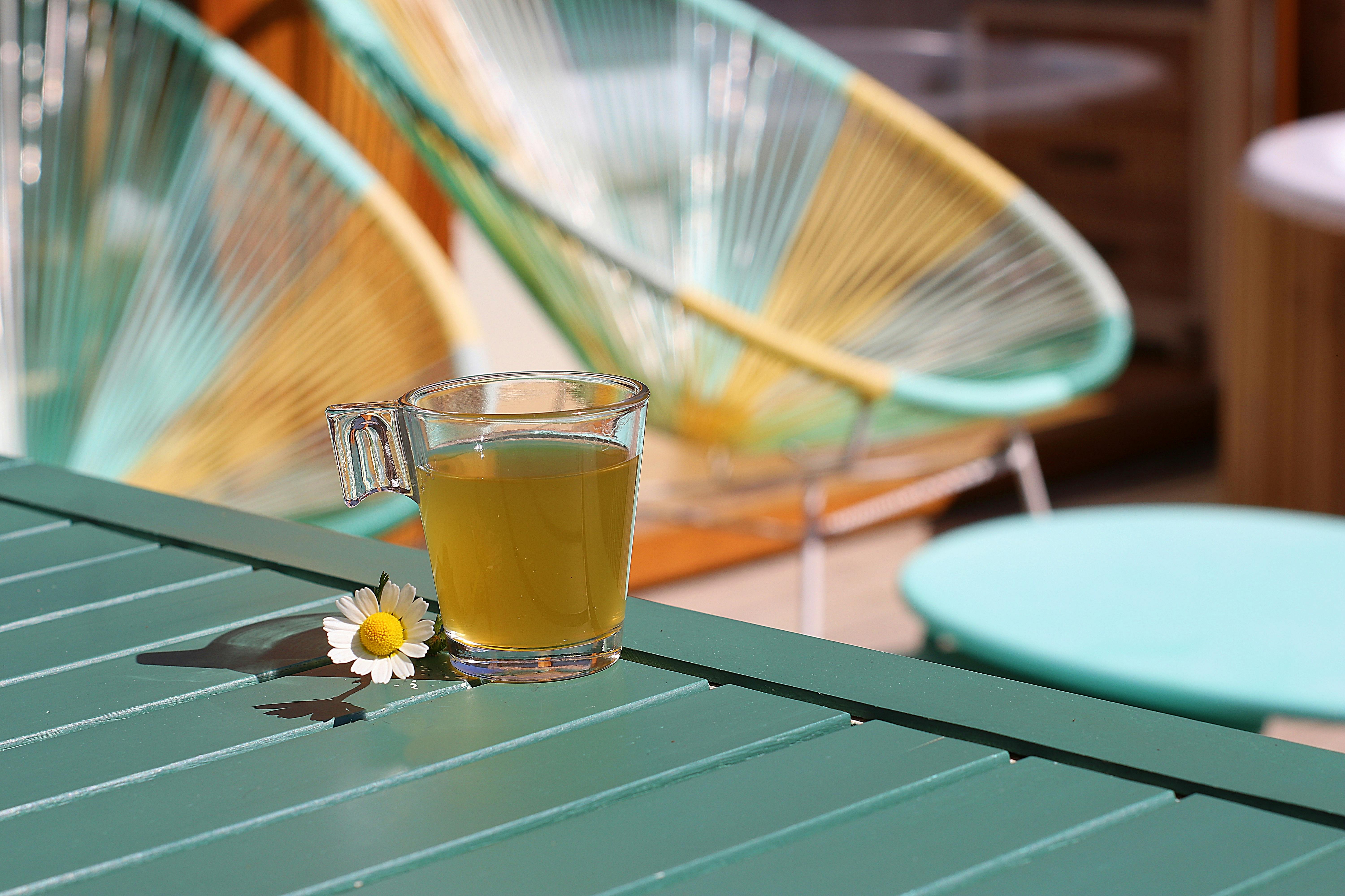 A close-up view of a wooden deck next to a stone patio, highlighting the texture and color differences between the two materials. The image focuses on