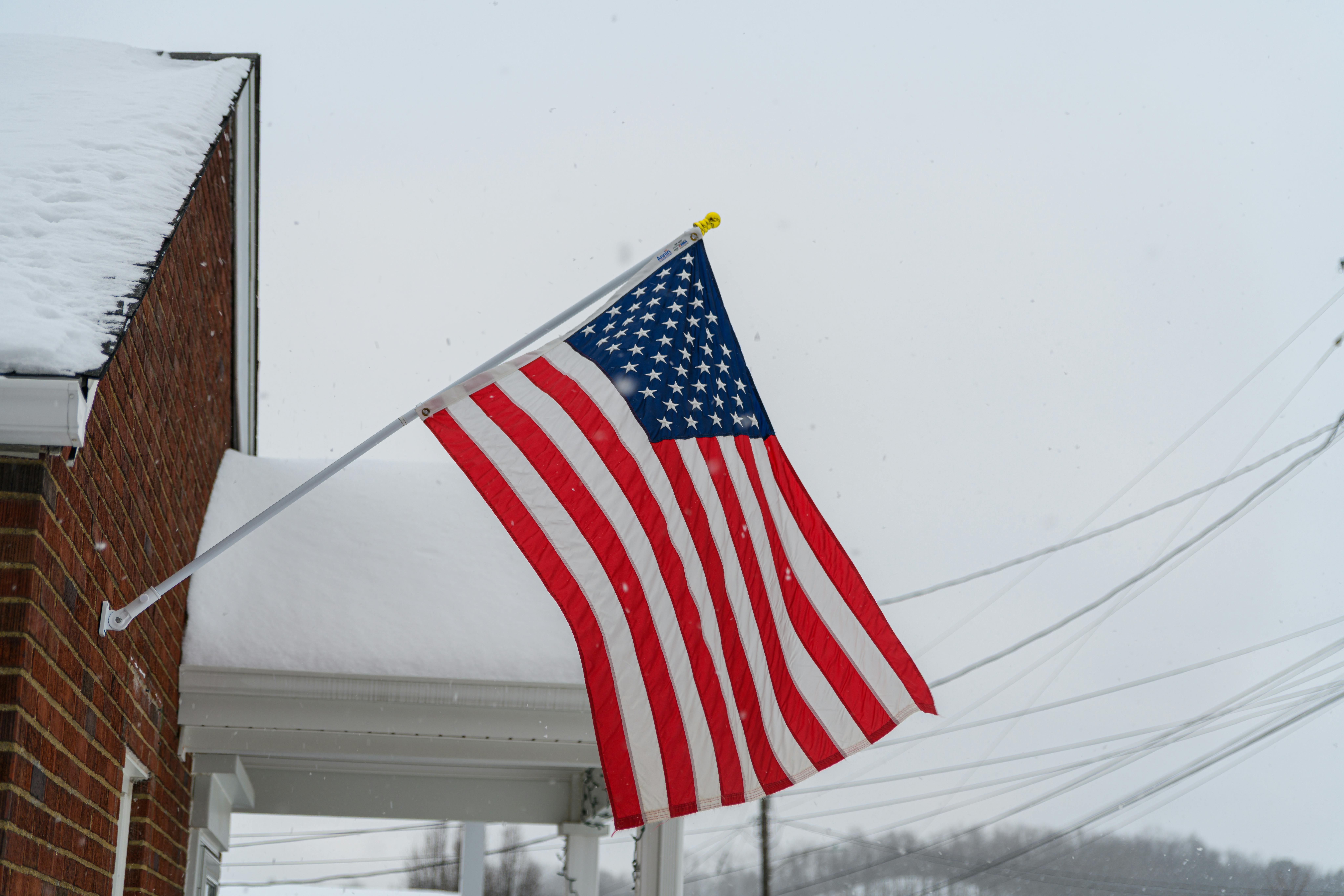 Create a high-resolution, photorealistic image of a snowy roof with visible ice dams at the edge and icicles hanging down, juxtaposed with another sec