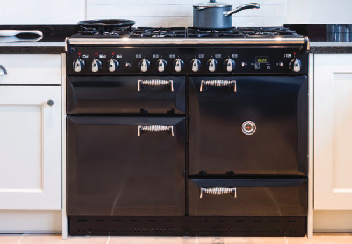 A modern kitchen with a black induction range and white cabinets